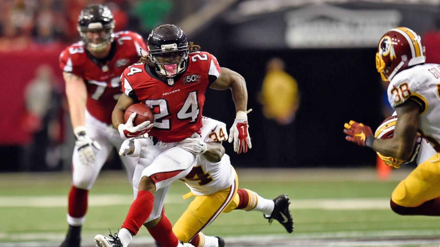Oct 11, 2015; Atlanta, GA, USA; Atlanta Falcons running back Devonta Freeman (24) runs against Washington Redskins strong safety Trenton Robinson (34) during the second quarter at the Georgia Dome. Mandatory Credit: Dale Zanine-USA TODAY Sports