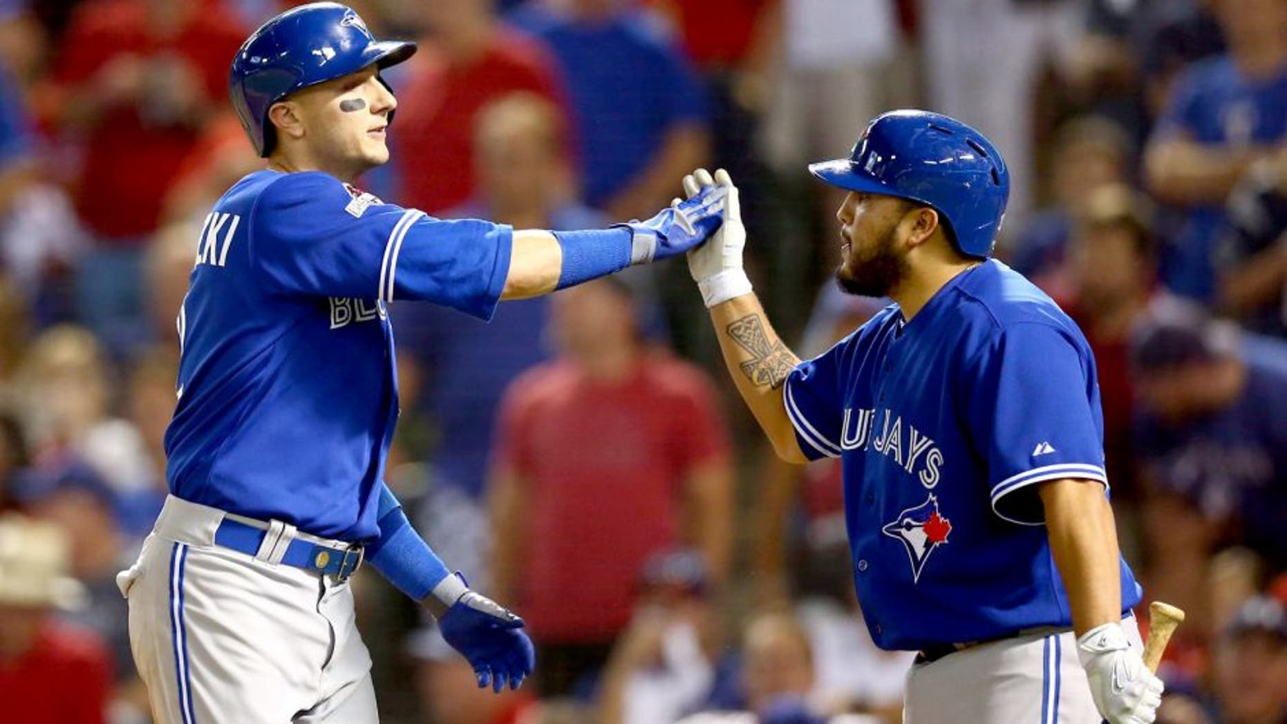 ARLINGTON, TX - OCTOBER 11: Troy Tulowitzki #2 of the Toronto Blue Jays celebrates with his teammate Dioner Navarro #30 after hitting a three run home run against Chi Chi Gonzalez #21 of the Texas Rangers in the sixth inning during game three of the American League Division Series on October 11, 2015 in Arlington, Texas. (Photo by Ronald Martinez/Getty Images)
