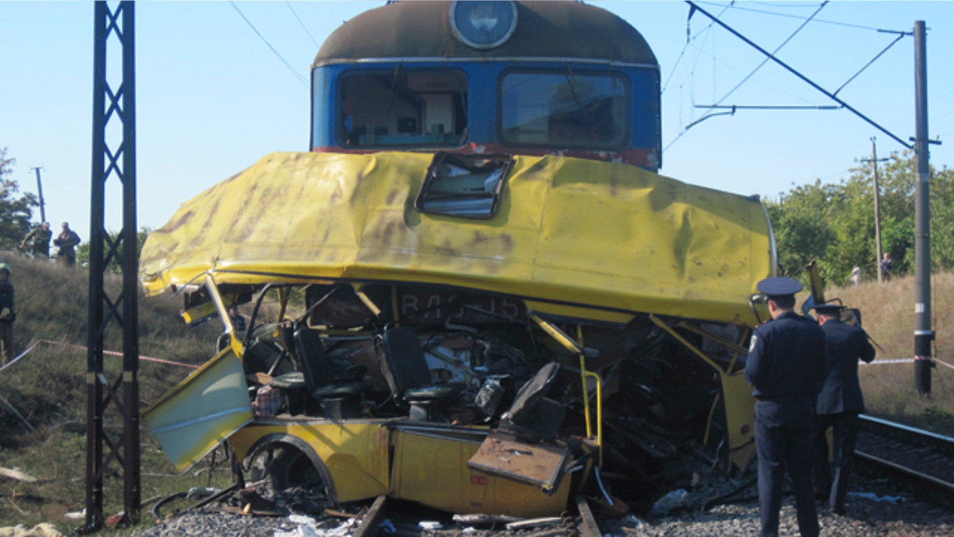 The remains of a bus lay next to a railway train at the site of an accident outside the town of Marhanets, Ukraine, Tuesday, Oct. 12, 2010. The crowded passenger bus collided with a train in eastern Ukraine Tuesday, killing 40 people and leaving 11 in critical condition, police said.