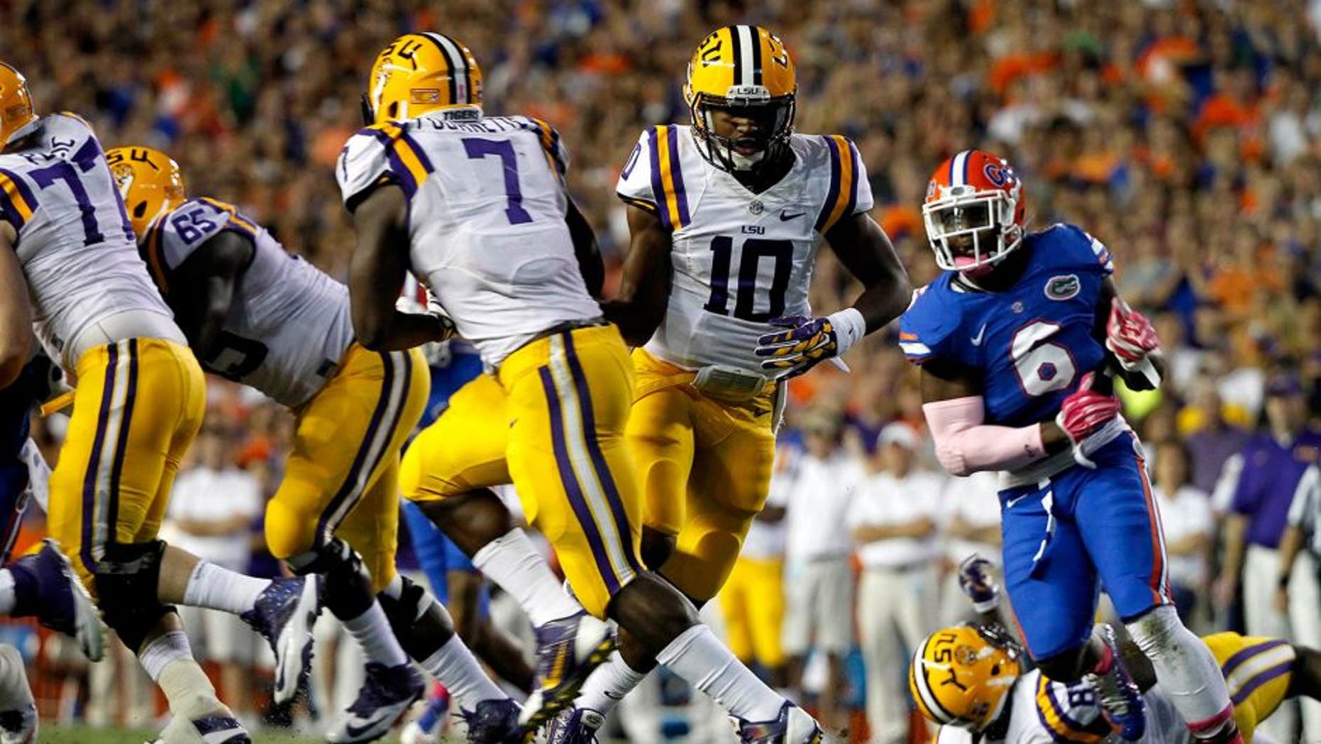 Oct 11, 2014; Gainesville, FL, USA; LSU Tigers quarterback Anthony Jennings (10) hands the ball off to running back Leonard Fournette (7) against the Florida Gators during the first half at Ben Hill Griffin Stadium. Mandatory Credit: Kim Klement-USA TODAY Sports