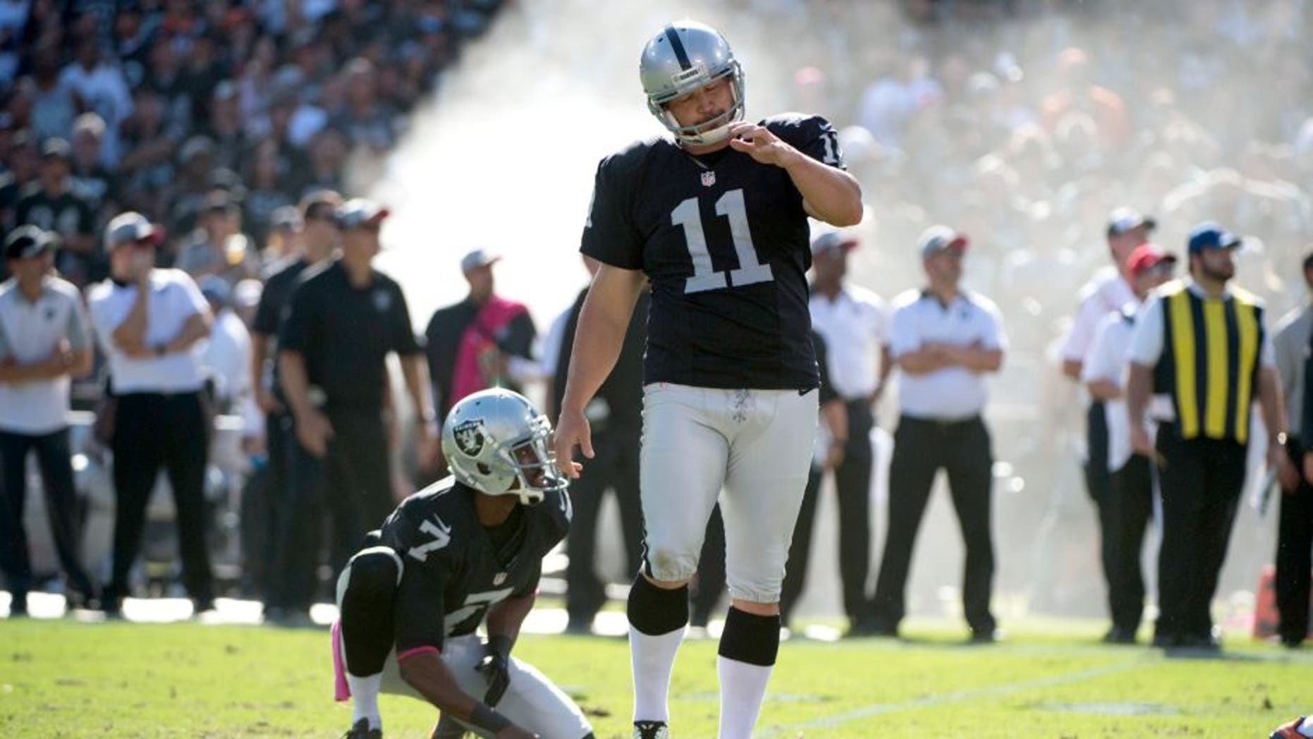 October 11, 2015; Oakland, CA, USA; Oakland Raiders kicker Sebastian Janikowski (11) reacts after missing a field goal from the hold by punter Marquette King (7) during the fourth quarter against the Denver Broncos at O.co Coliseum. The Raiders defeated the Broncos 16-10. Mandatory Credit: Kyle Terada-USA TODAY Sports