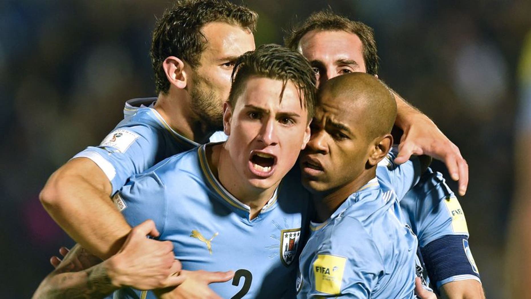 Uruguay's forward Diego Rolan (R, front) celebrates with teammates Jose Maria Gimenez (C), Christian Stuani (L) and Diego Godin after scoring against Colombia during their Russia 2018 FIFA World Cup South American Qualifiers football match, at the Estadio Centenario stadium in Montevideo, on October 13, 2015. AFP PHOTO / PABLO PORCIUNCULA (Photo credit should read PABLO PORCIUNCULA/AFP/Getty Images)