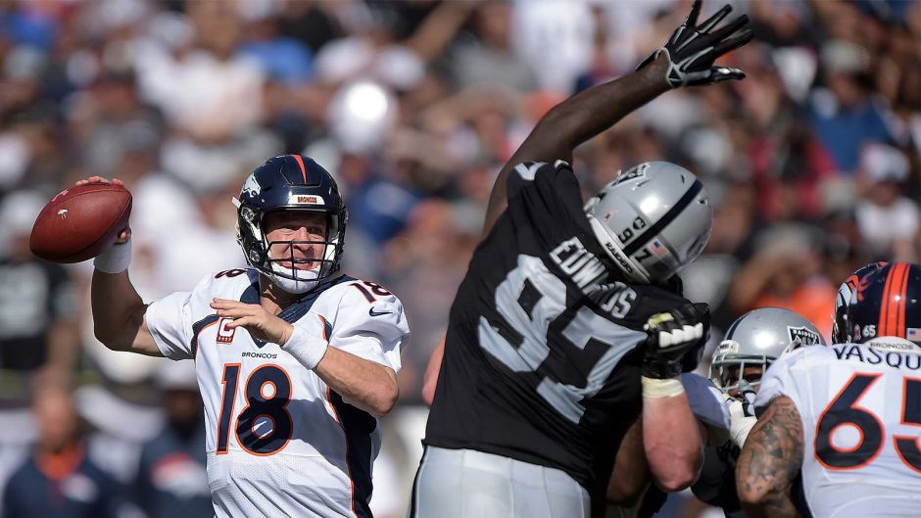 Oct 11, 2015; Oakland, CA, USA; Denver Broncos quarterback Peyton Manning (18) throws a pass under pressure by Oakland Raiders defensive end Mario Edwards Jr. (97) at O.co Coliseum. Mandatory Credit: Kirby Lee-USA TODAY Sports