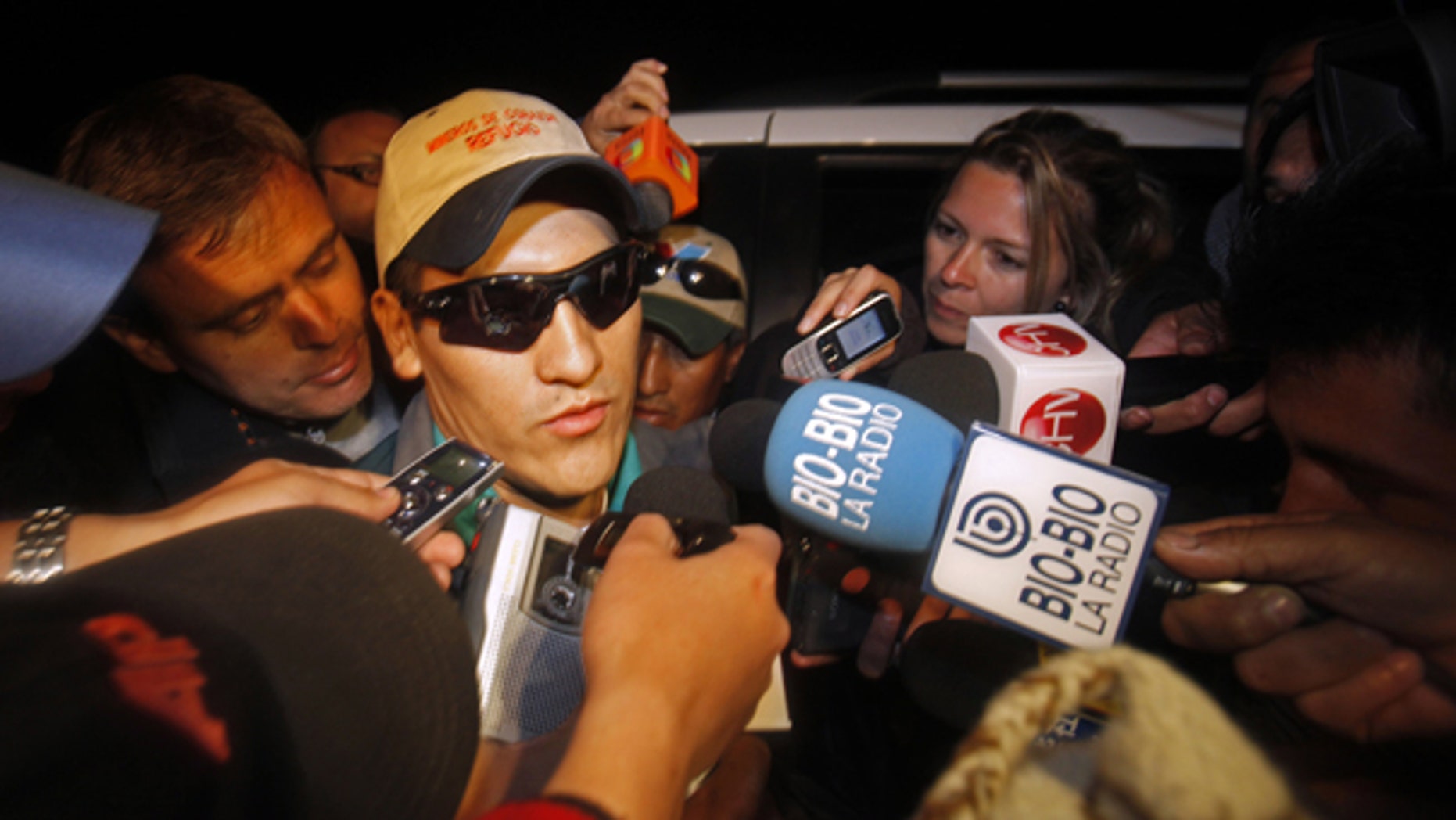 Oct. 14: Rescued miner Carlos Mamani, from Bolivia, is surrounded by the press as he arrives at his home in Copiapo, Chile.