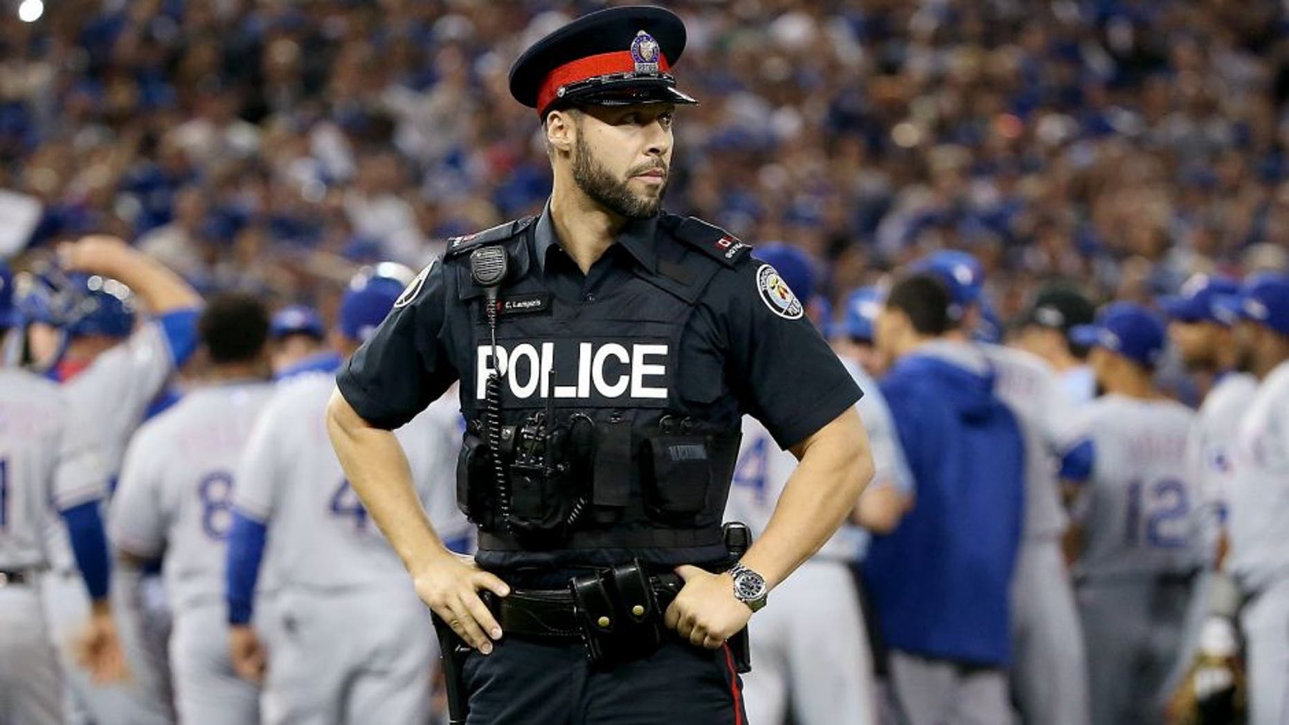 TORONTO, ON - OCTOBER 14: As the benches clear a Toronto police officer is seen in game five of the American League Division Series between the Texas Rangers and the Toronto Blue Jays at Rogers Centre on October 14, 2015 in Toronto, Canada. (Photo by Tom Szczerbowski/Getty Images)