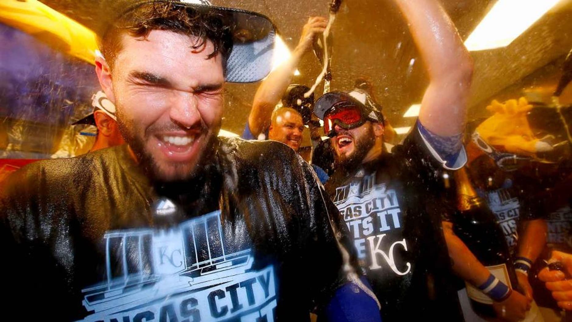 KANSAS CITY, MO - OCTOBER 14: Eric Hosmer #35 of the Kansas City Royals, left, celebrates with teammates in the clubhouse after defeating the Houston Astros 7-2 in game five of the American League Divison Series at Kauffman Stadium on October 14, 2015 in Kansas City, Missouri. (Photo by Jamie Squire/Getty Images)