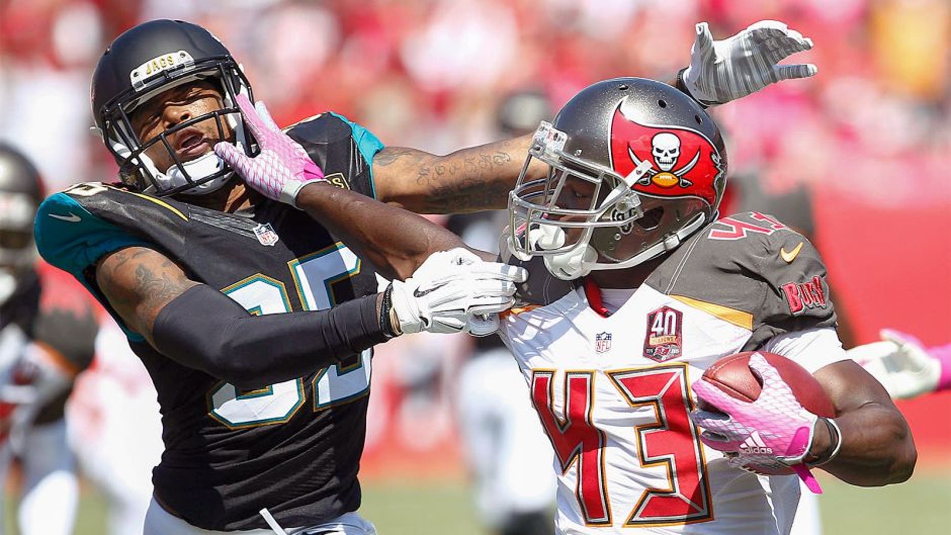 Oct 11, 2015; Tampa, FL, USA; Jacksonville Jaguars cornerback Demetrius McCray (35)is stiff armed by Tampa Bay Buccaneers running back Bobby Rainey (43) during the second quarter of an NFL football game at Raymond James Stadium. Mandatory Credit: Reinhold Matay-USA TODAY Sports