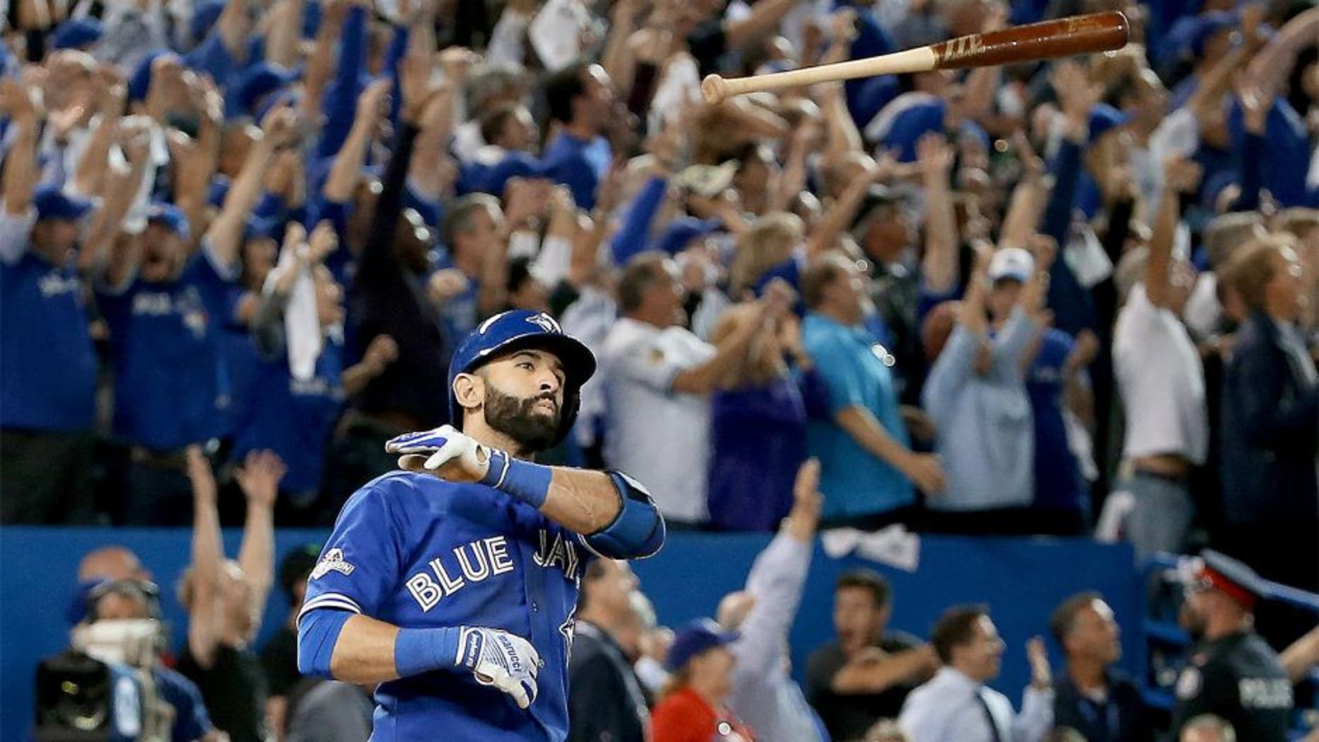 TORONTO, ON - OCTOBER 14: Jose Bautista #19 of the Toronto Blue Jays throws his bat up in the air after he hits a three-run home run in the seventh inning against the Texas Rangers in game five of the American League Division Series at Rogers Centre on October 14, 2015 in Toronto, Canada. (Photo by Tom Szczerbowski/Getty Images)