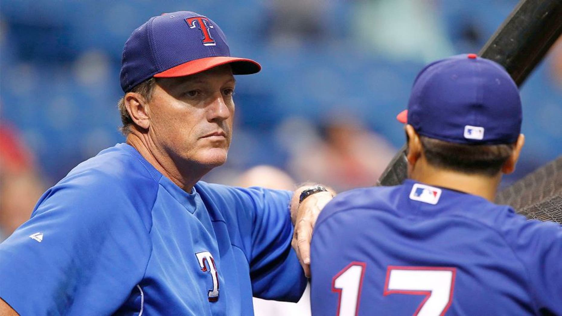 Apr 4, 2014; St. Petersburg, FL, USA; Texas Rangers batting coach Dave Magadan (14) talks with left fielder Shin-Soo Choo (17) prior to the game against the Tampa Bay Rays at Tropicana Field. Mandatory Credit: Kim Klement-USA TODAY Sports