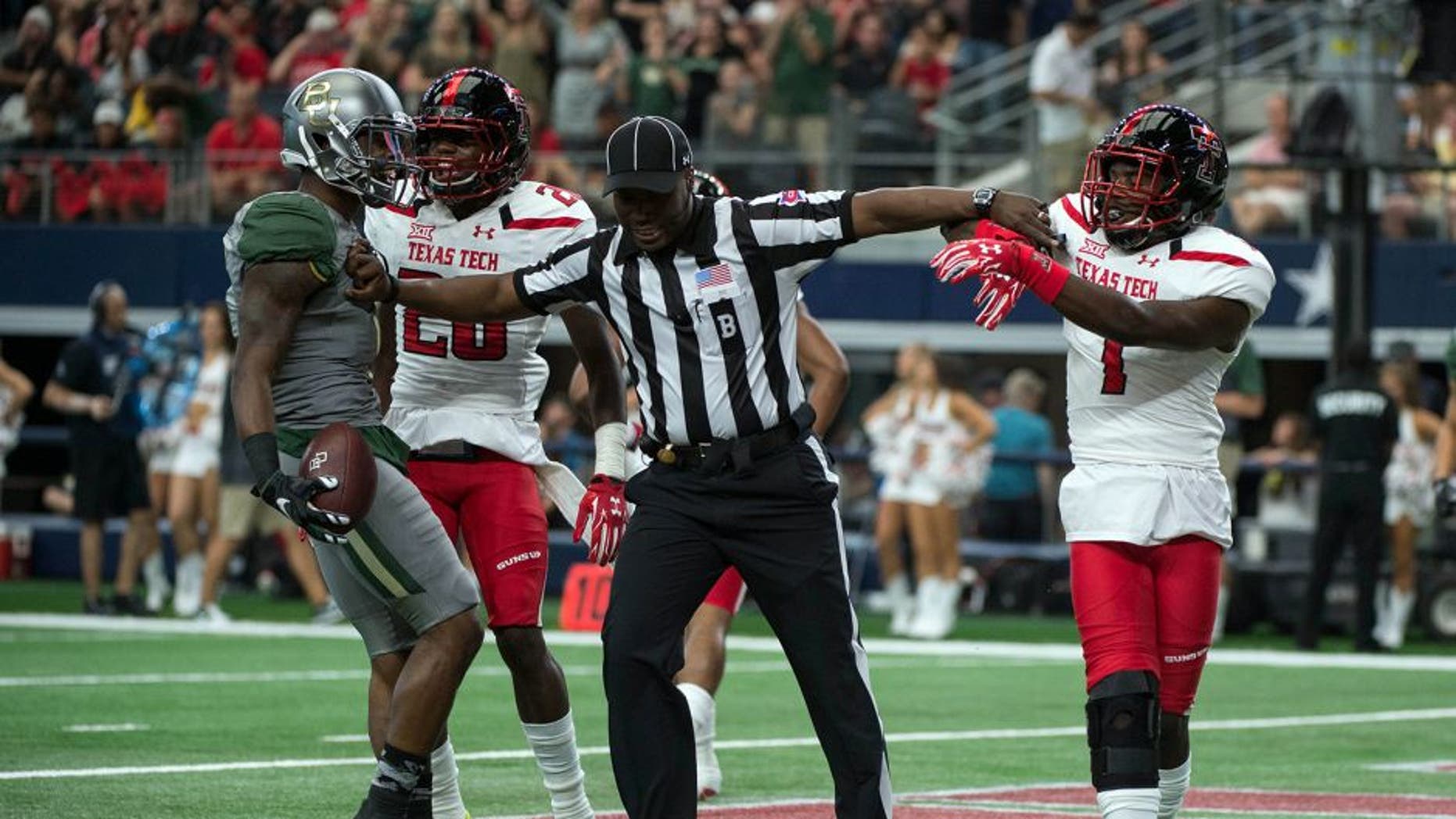 Oct 3, 2015; Arlington, TX, USA; Baylor Bears wide receiver Corey Coleman (1) and Texas Tech Red Raiders defensive back Jah'Shawn Johnson (7) are separated by back judge Lyndon Nixon after Coleman scores a touchdown during the first quarter at AT&T Stadium. Mandatory Credit: Jerome Miron-USA TODAY Sports