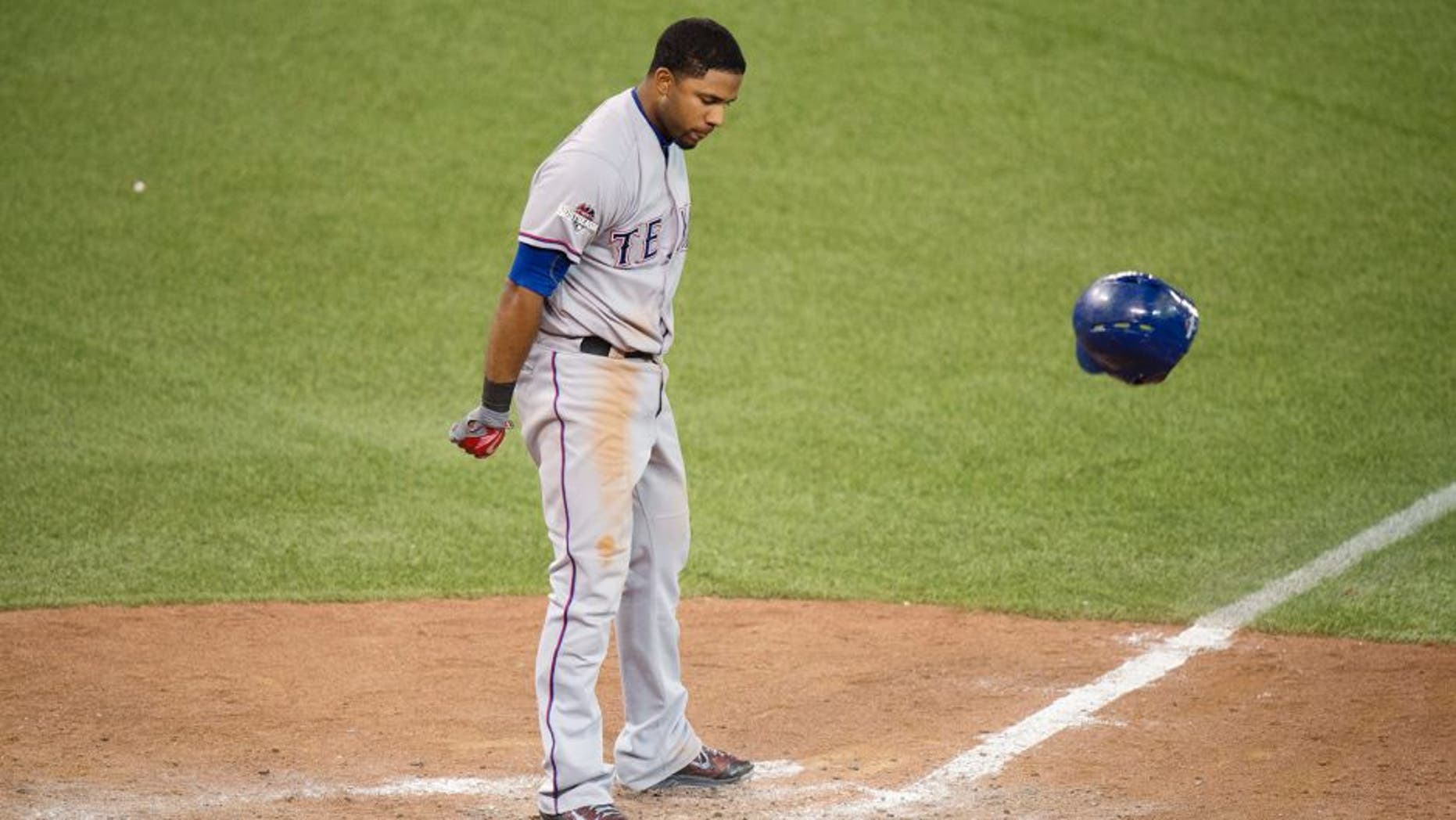 Texas Rangers' Elvis Andrus tosses his helmet after striking out during the eighth inning in Game 5 of baseball's American League Division Series against the Toronto Blue, Wednesday, Oct. 14, 2015, in Toronto. The Blue Jays clinched their first trip to the American League Championship Series since 1993, overcoming one of the most bizarre plays in playoff history by taking advantage of three Rangers errors for a 6-3 victory. (Darren Calabrese/The Canadian Press via AP) MANDATORY CREDIT