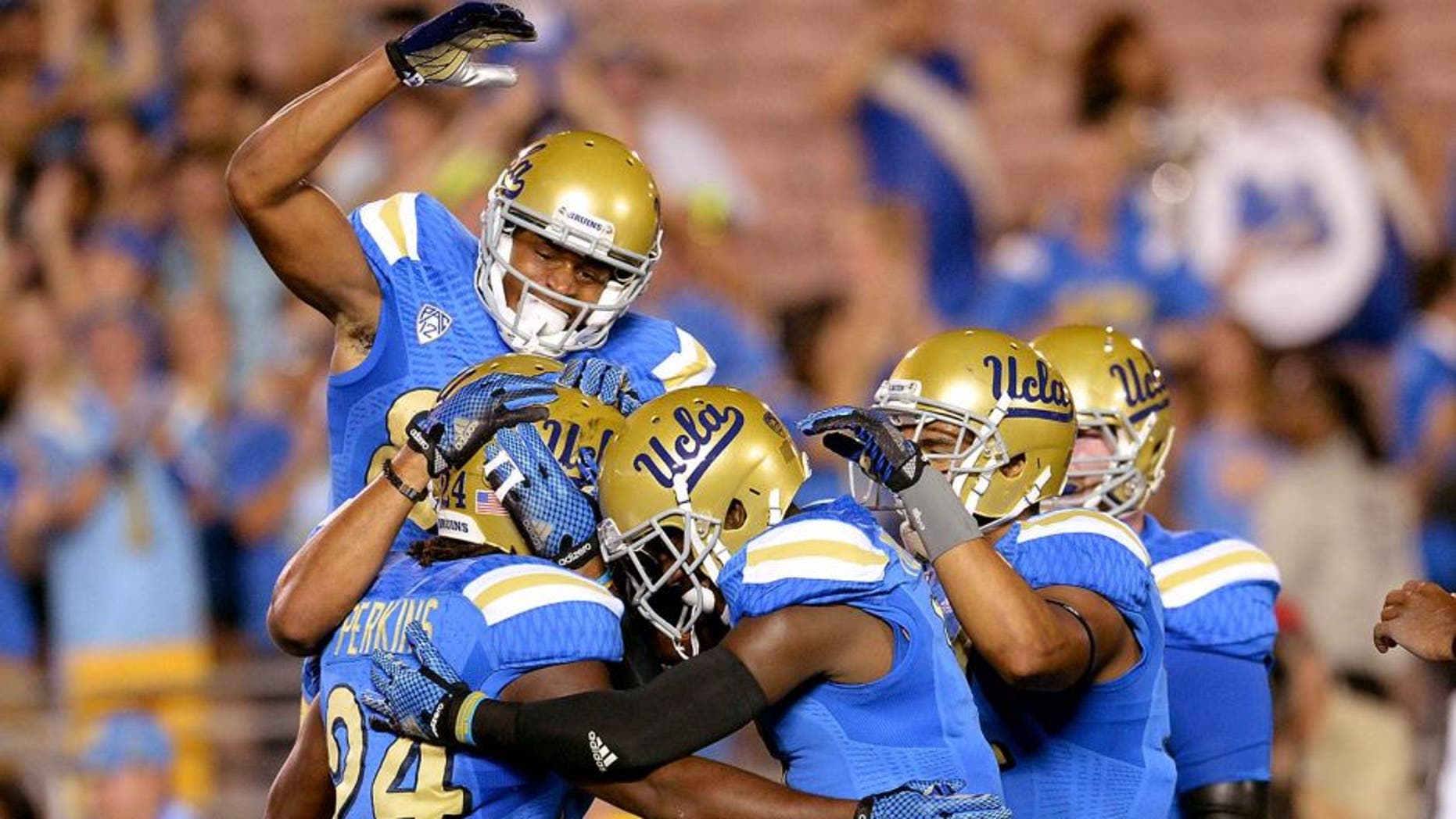 Sep 6, 2014; Pasadena, CA, USA; UCLA Bruins celebrate with running back Paul Perkins (24) after scoring a touchdown in the first quarter of the game against the Memphis Tigers at the Rose Bowl. Mandatory Credit: Jayne Kamin-Oncea-USA TODAY Sports