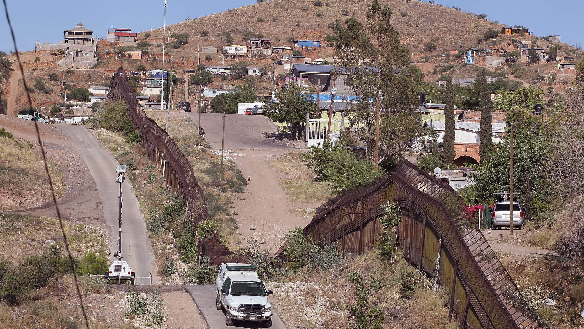 NOGALES, AZ - JUNE 02: A U.S. U.S. Customs and Border Protection agent drives along a fence which separates the cities of Nogales, Arizona and Nogales, Sonora Mexico, a frequent crossing point for people entering the United States illegally, June 2, 2010 in Nogales, Arizona. During the 2009 fiscal year 540,865 undocumented immigrants were apprehended entering the United States illegally along the Mexican border, 241,000 of those were captured in the 262 mile stretch of the border known as the Tucson Sector. (Photo by Scott Olson/Getty Images)