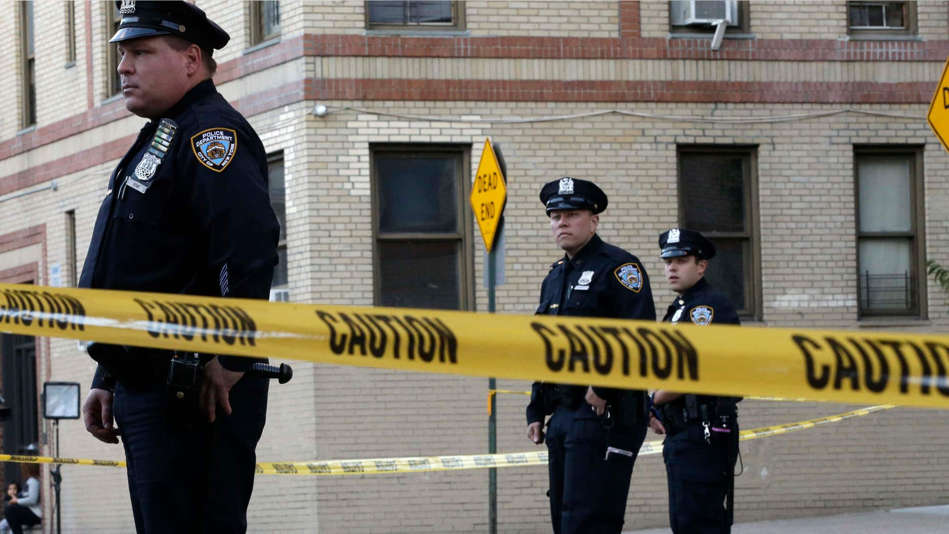 Oct. 15, 2015: Police officers stand guard near an apartment building in the Bronx borough of New York.