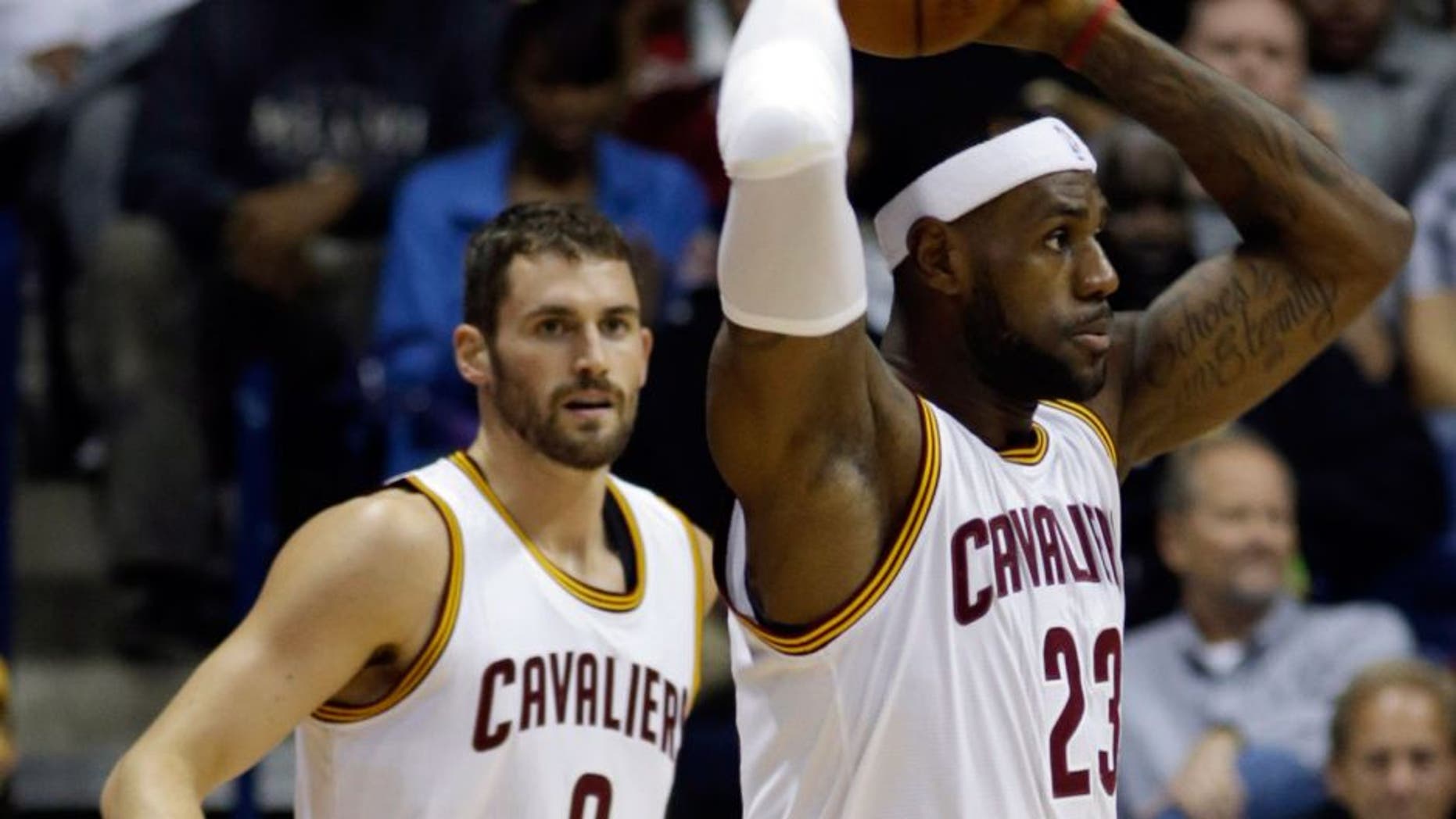 Cleveland Cavaliers forward LeBron James (23) looks to pass against the Indiana Pacers in the first half of an NBA preseason basketball game, Wednesday, Oct. 15, 2014, in Cincinnati. Cavaliers forward Kevin Love (0) watches. (AP Photo/Al Behrman)