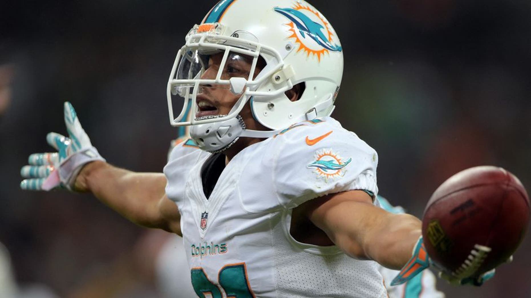Sep 28, 2014; London, UNITED KINGDOM; Miami Dolphins cornerback Brent Grimes (21) celebrates after an interception against the Oakland Raiders in the NFL International Series game at Wembley Stadium. The Dolphins defeated the Raiders 38-14. Mandatory Credit: Kirby Lee-USA TODAY Sports