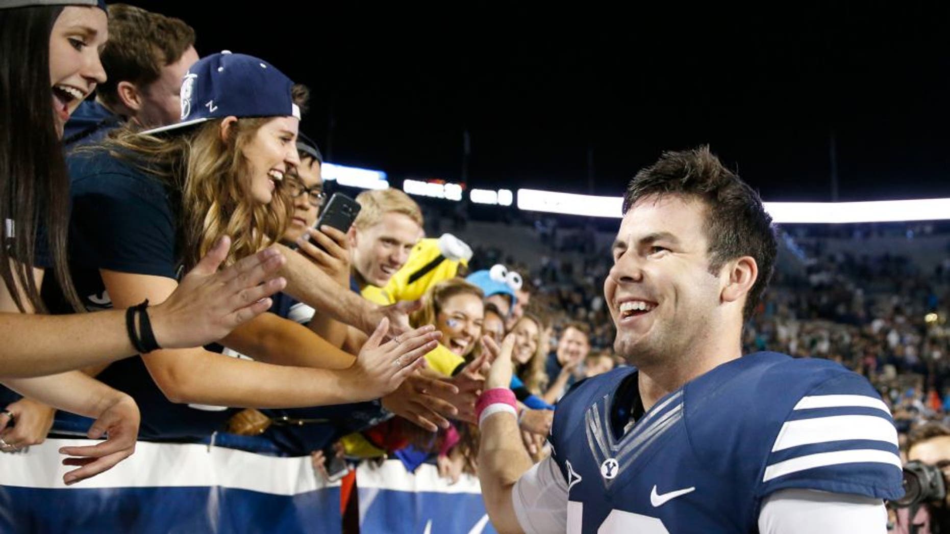 Oct 16, 2015; Provo, UT, USA; Brigham Young Cougars quarterback Tanner Mangum (12) greets fans after their 38-24 win against the Cincinnati Bearcats at Lavell Edwards Stadium. Mandatory Credit: Jeff Swinger-USA TODAY Sports