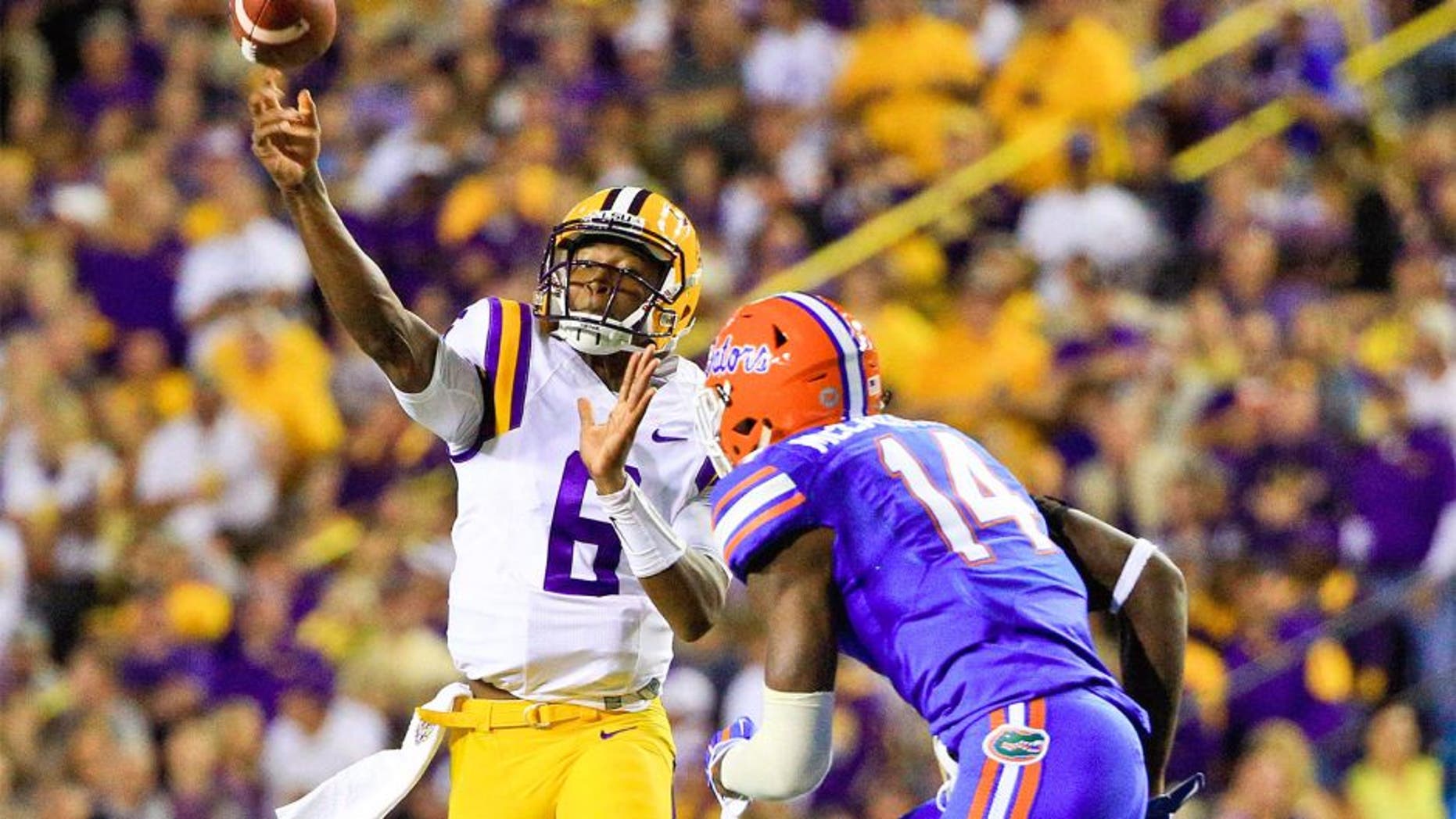 Oct 17, 2015; Baton Rouge, LA, USA; LSU Tigers quarterback Brandon Harris (6) throws as Florida Gators defensive lineman Alex McCalister (14) defends during the second quarter of a game at Tiger Stadium. Mandatory Credit: Derick E. Hingle-USA TODAY Sports