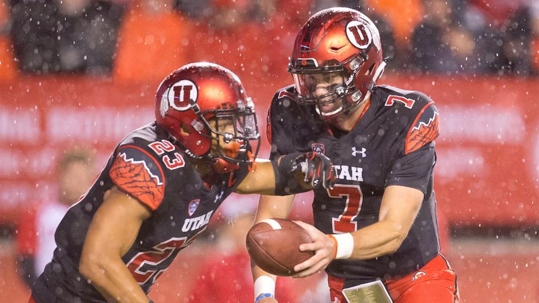 Oct 17, 2015; Salt Lake City, UT, USA; Utah Utes quarterback Travis Wilson (7) hands off to running back Devontae Booker (23) during the first half against the Arizona State Sun Devils at Rice-Eccles Stadium. Mandatory Credit: Russ Isabella-USA TODAY Sports