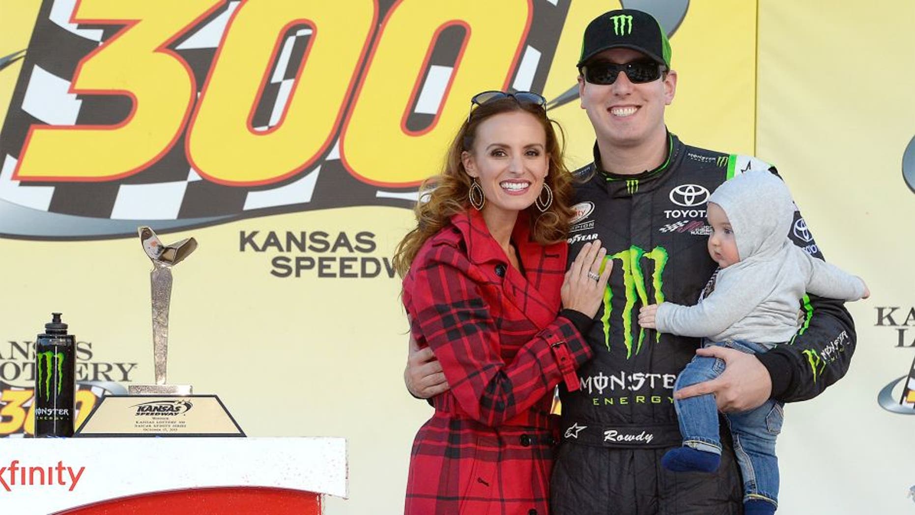 KANSAS CITY, KS - OCTOBER 17: Kyle Busch, driver of the #54 Monster Energy Toyota, poses in Victory Lane with his wife, Samantha, and son, Brexton during the NASCAR XFINITY Series Kansas Lottery 300 at Kansas Speedway on October 17, 2015 in Kansas City, Kansas. (Photo by Robert Laberge/NASCAR via Getty Images)