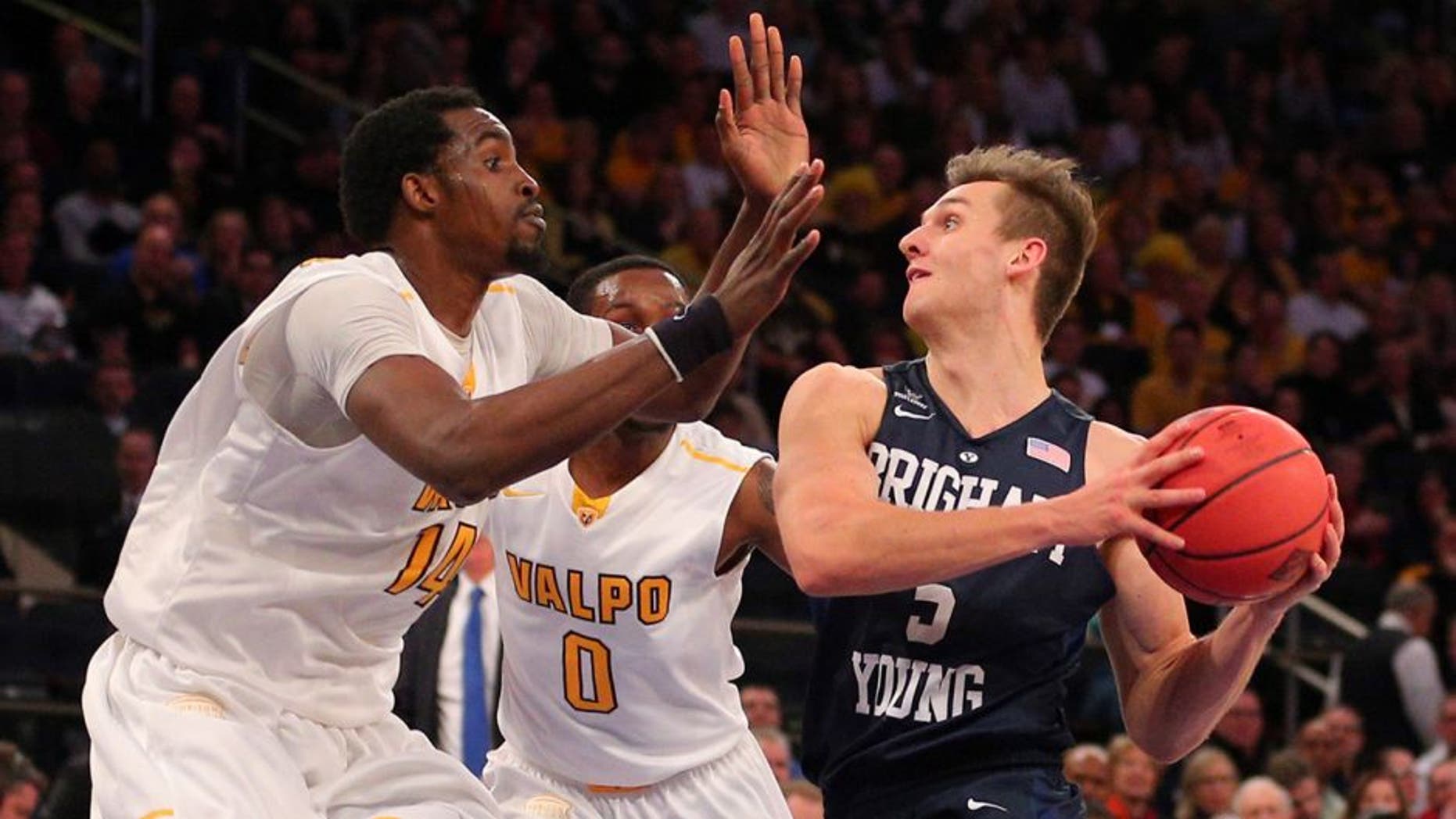Mar 29, 2016; New York, NY, USA; BYU Cougars guard Kyle Collinsworth (5) prepares to shoot the ball as Valparaiso Crusaders center Vashil Fernandez (14) and guard Keith Carter (0) defend during the second half of a semifinal game of the 2016 NIT basketball tournament at Madison Square Garden. The Crusaders won 72-70. Mandatory Credit: Brad Penner-USA TODAY Sports