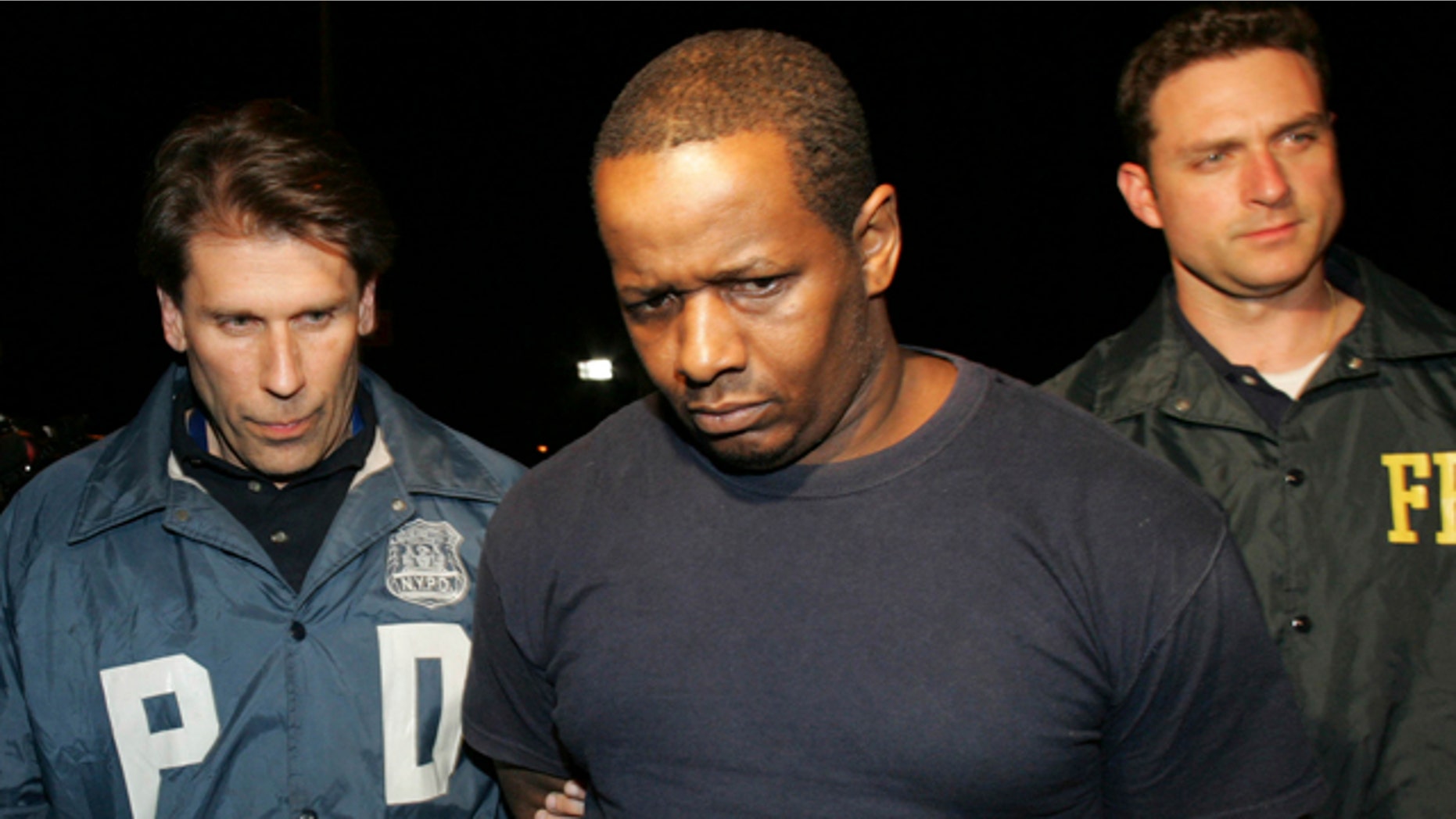 In this May 21, 2009 file photo, James Cromitie, center, is led by police officers from a federal building in New York after being arrested for plotting to bomb New York synagogues and shoot down military aircraft.