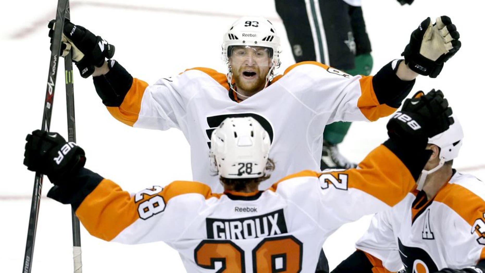 Philadelphia Flyers right wing Jakub Voracek (93) celebrates the game winning goal with teammates center Claude Giroux (28) and defenseman Mark Streit (32) during overtime of an NHL hockey game against the Dallas Stars Saturday, Oct. 18, 2014, in Dallas. The Flyers won 6-5. (AP Photo/LM Otero)