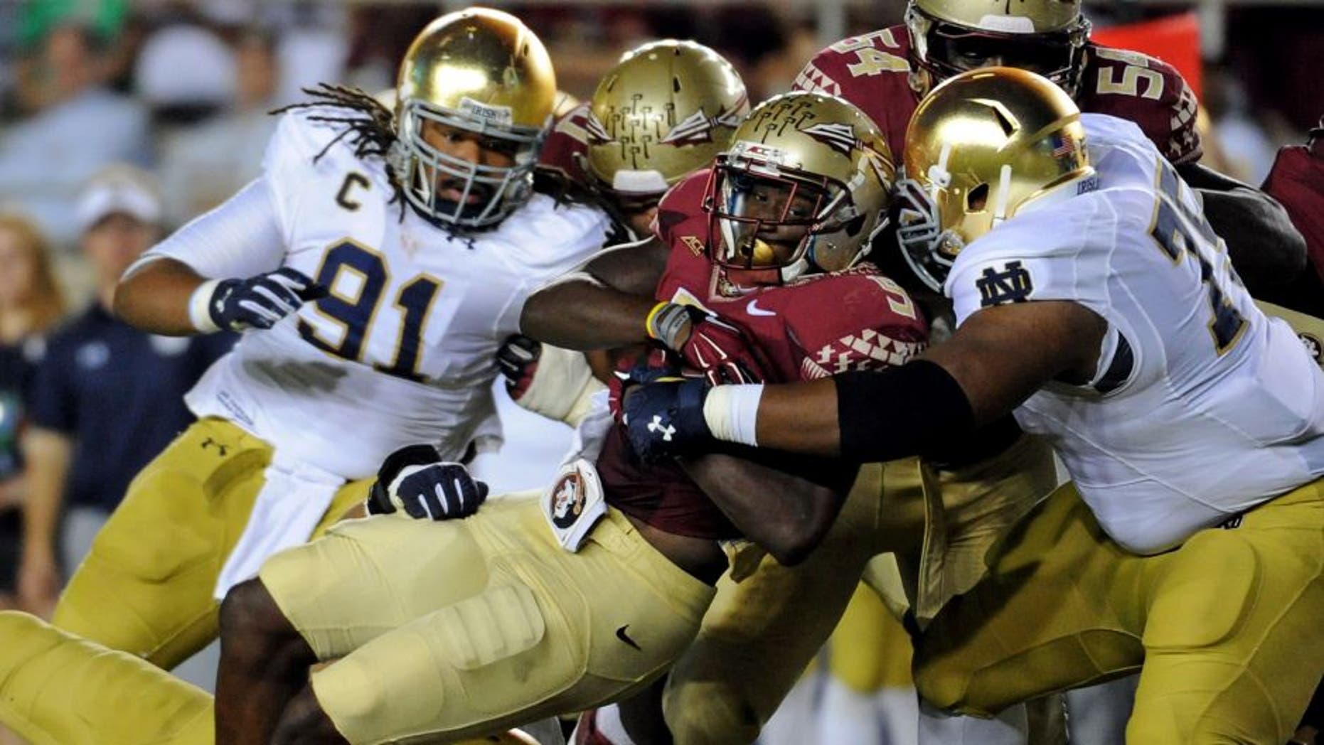 Oct 18, 2014; Tallahassee, FL, USA; Florida State Seminoles running back Karlos Williams (9) runs the ball and is tackled by Notre Dame Fighting Irish defensive lineman Daniel Cage (75) during the first half at Doak Campbell Stadium. Mandatory Credit: Melina Vastola-USA TODAY Sports