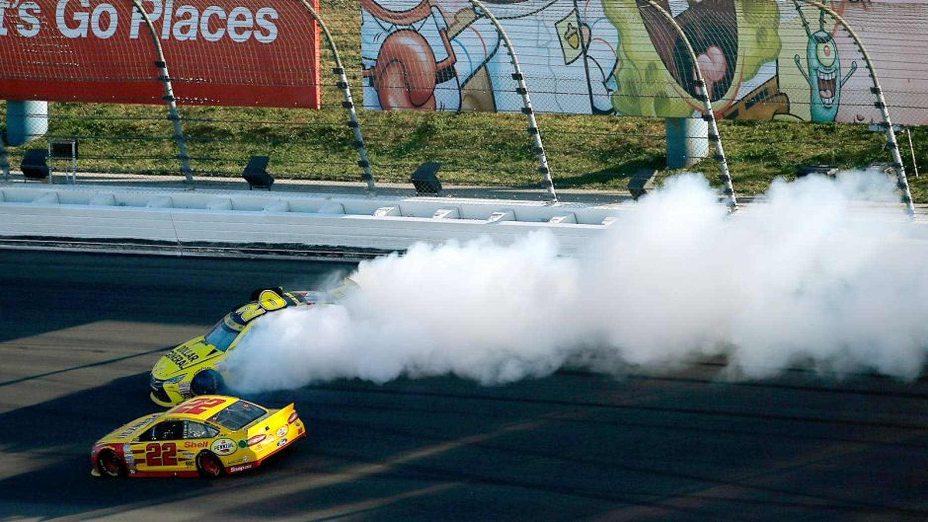 KANSAS CITY, KS - OCTOBER 18: Matt Kenseth, driver of the #20 Dollar General Toyota, spins as Joey Logano, driver of the #22 Shell Pennzoil Ford, races by during the NASCAR Sprint Cup Series Hollywood Casino 400 at Kansas Speedway on October 18, 2015 in Kansas City, Kansas. (Photo by Todd Warshaw/Getty Images)