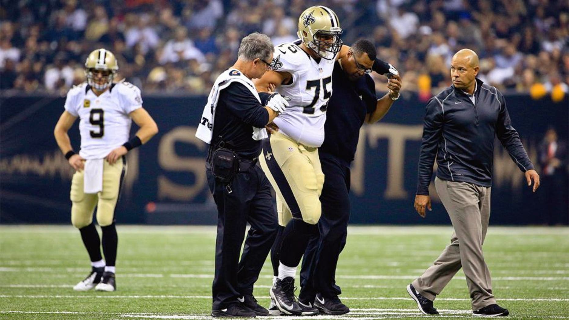 Oct 15, 2015; New Orleans, LA, USA; New Orleans Saints offensive tackle Andrus Peat (75) is helped off the field during the first quarter of a game against the Atlanta Falcons at the Mercedes-Benz Superdome. Mandatory Credit: Derick E. Hingle-USA TODAY Sports