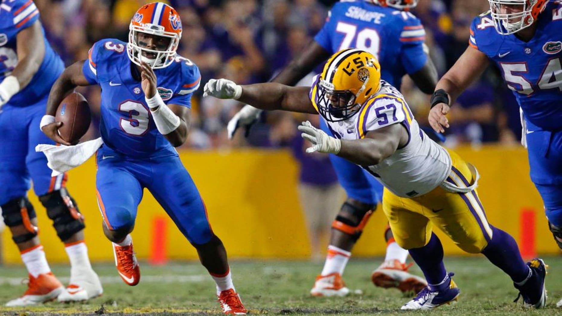Florida quarterback Treon Harris (3) carries past LSU defensive tackle Davon Godchaux (57) in the second half of an NCAA college football game in Baton Rouge, La., Saturday, Oct. 17, 2015. LSU won 35-28. (AP Photo/Gerald Herbert)