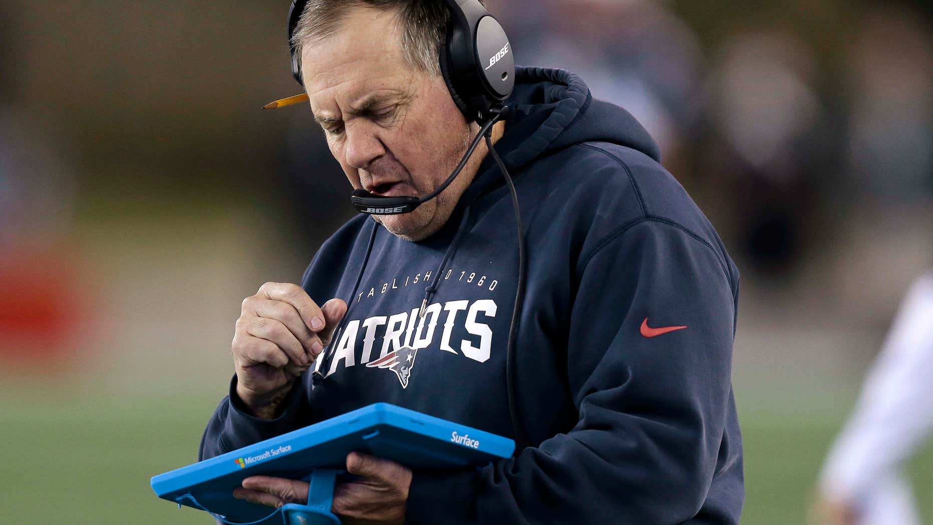 FILE - In this Dec. 6, 2015, file photo, New England Patriots head coach Bill Belichick studies a tablet device along the sideline during the first half of an NFL football game against the Philadelphia Eagles in Foxborough, Mass.