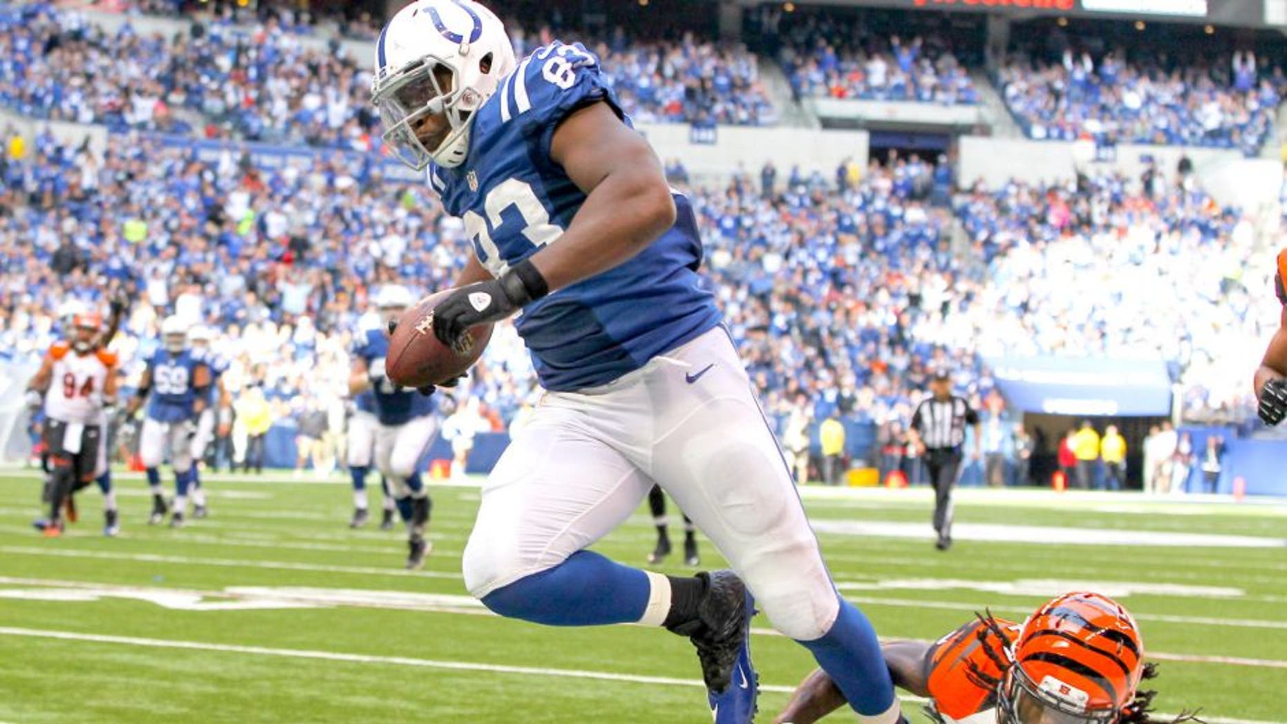 Oct 19, 2014; Indianapolis, IN, USA; Indianapolis Colts tight end Dwayne Allen (83) avoids the tackle of Cincinnati Bengals cornerback Dre Kirkpatrick (27) to score a touchdown during the third quarter at Lucas Oil Stadium. The Colts defeated the Bengals 27-0. Mandatory Credit: Pat Lovell-USA TODAY Sports