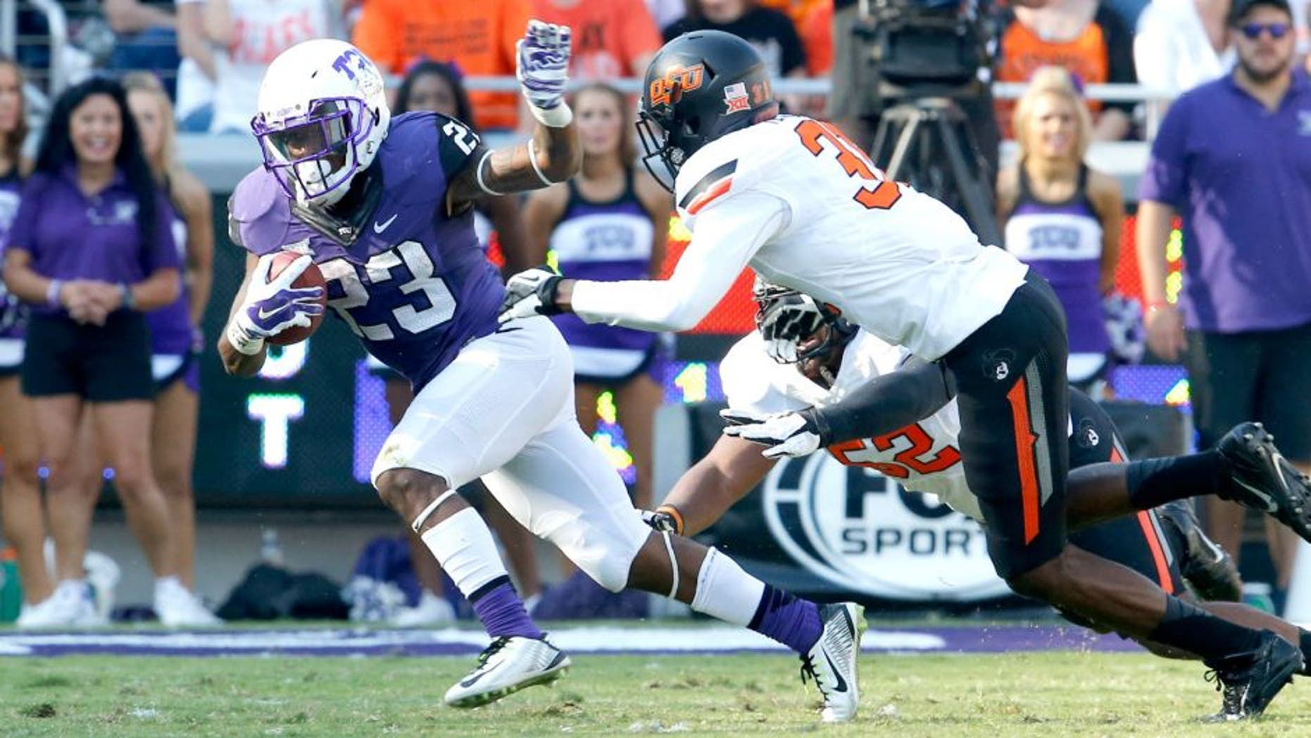Oct 18, 2014; Fort Worth, TX, USA; TCU Horned Frogs tailback B.J. Catalon (23) runs with the ball against Oklahoma State Cowboys safety Tre Flowers (31) at Amon G. Carter Stadium. Mandatory Credit: Matthew Emmons-USA TODAY Sports