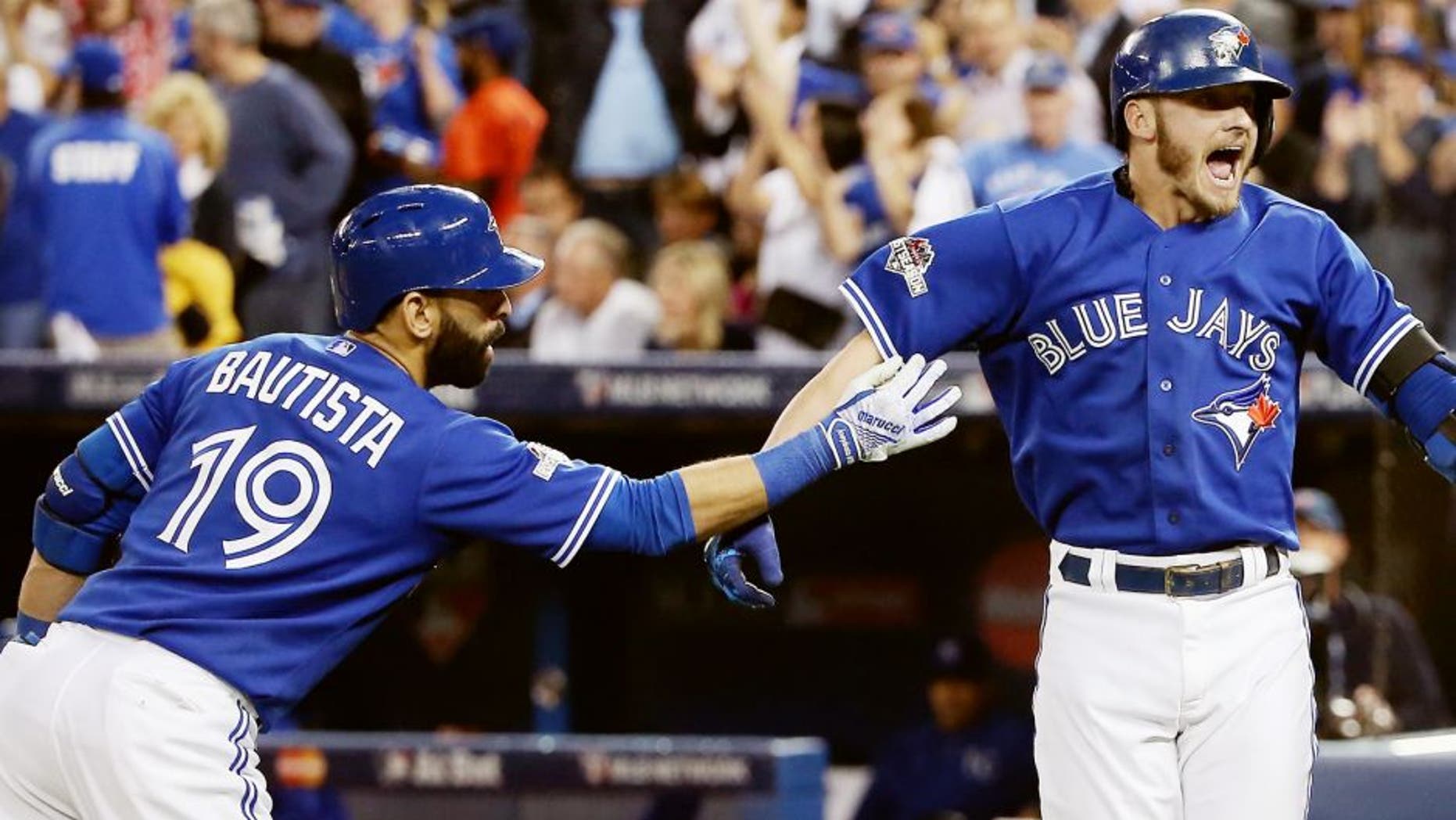 TORONTO, ON - OCTOBER 19: Josh Donaldson #20 of the Toronto Blue Jays celebrates with Jose Bautista #19 of the Toronto Blue Jays after hitting a two-run home run in the third inning against the Kansas City Royals during game three of the American League Championship Series at Rogers Centre on October 19, 2015 in Toronto, Canada. (Photo by Tom Szczerbowski/Getty Images)