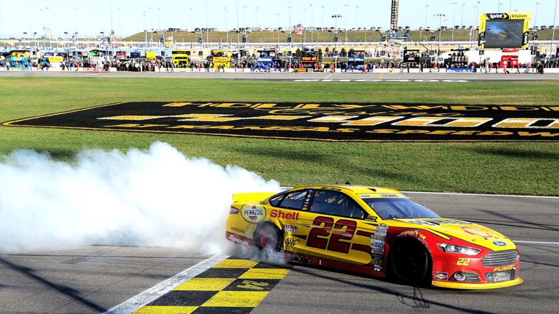KANSAS CITY, KS - OCTOBER 18: Joey Logano, driver of the #22 Shell Pennzoil Ford, celebrates with a burnout after winning the NASCAR Sprint Cup Series Hollywood Casino 400 at Kansas Speedway on October 18, 2015 in Kansas City, Kansas. (Photo by Ed Zurga/Getty Images)