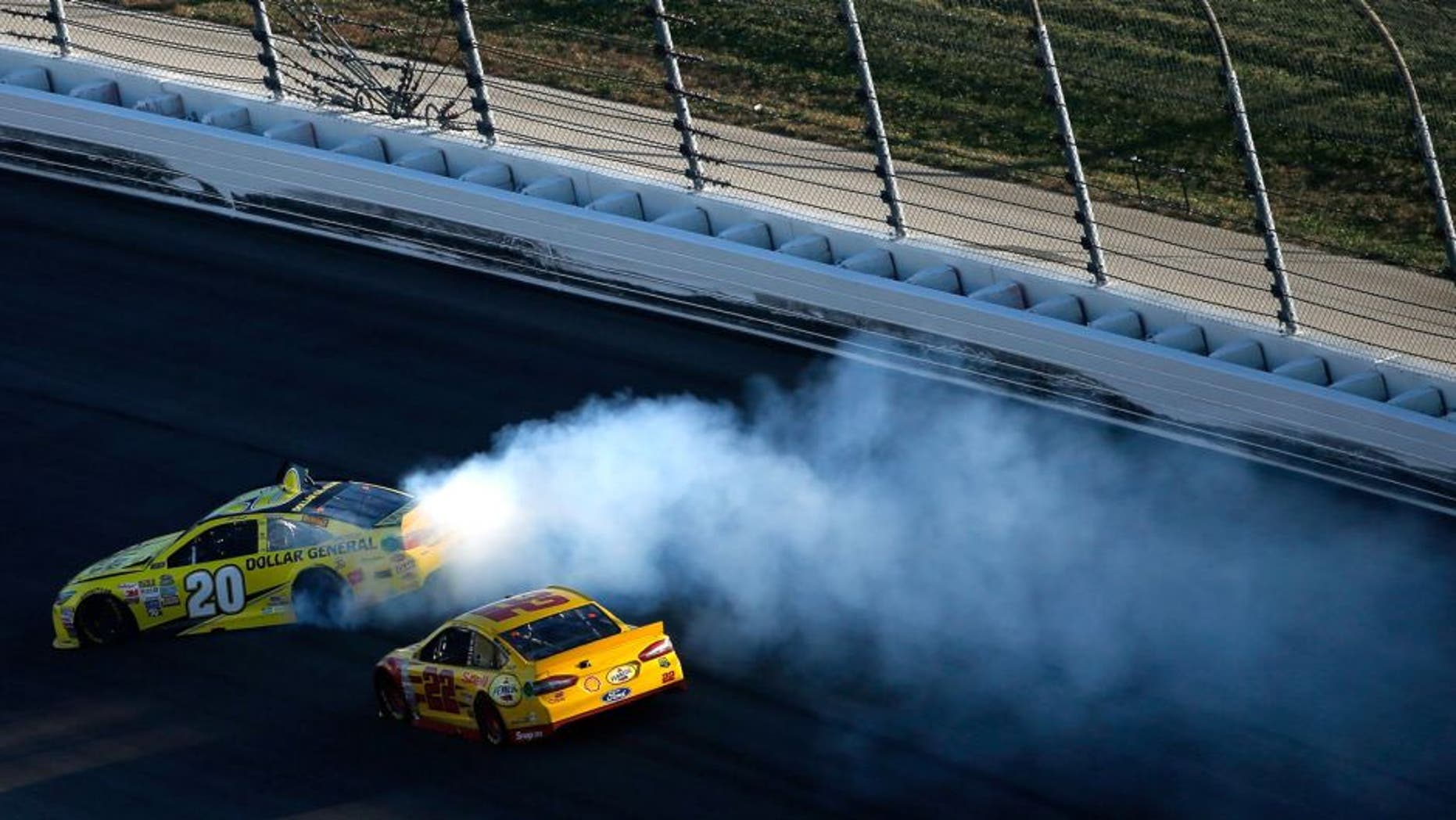 KANSAS CITY, KS - OCTOBER 18: Matt Kenseth, driver of the #20 Dollar General Toyota, spins as Joey Logano, driver of the #22 Shell Pennzoil Ford, races by during the NASCAR Sprint Cup Series Hollywood Casino 400 at Kansas Speedway on October 18, 2015 in Kansas City, Kansas. (Photo by Todd Warshaw/Getty Images)