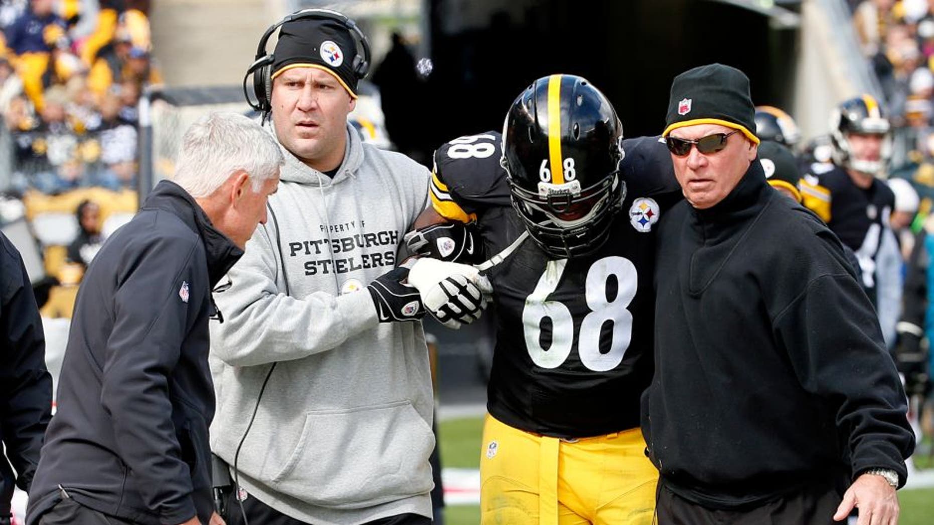 In this Sunday, Oct. 18, 2015, photo, Pittsburgh Steelers tackle Kelvin Beachum (68) is helped from the field by quarterback Ben Roethlisberger, center left, towards Steelers head athletic trainer John Norwig, left, after he was injured in the NFL football game against the Arizona Cardinals in Pittsburgh. Beachum did not return to the game. The Steelers announced Monday, Oct. 19, that they placed Beachum on the Reserve/Injured List and signed offensive tackle Byron Stingily. (AP Photo/Gene J. Puskar)