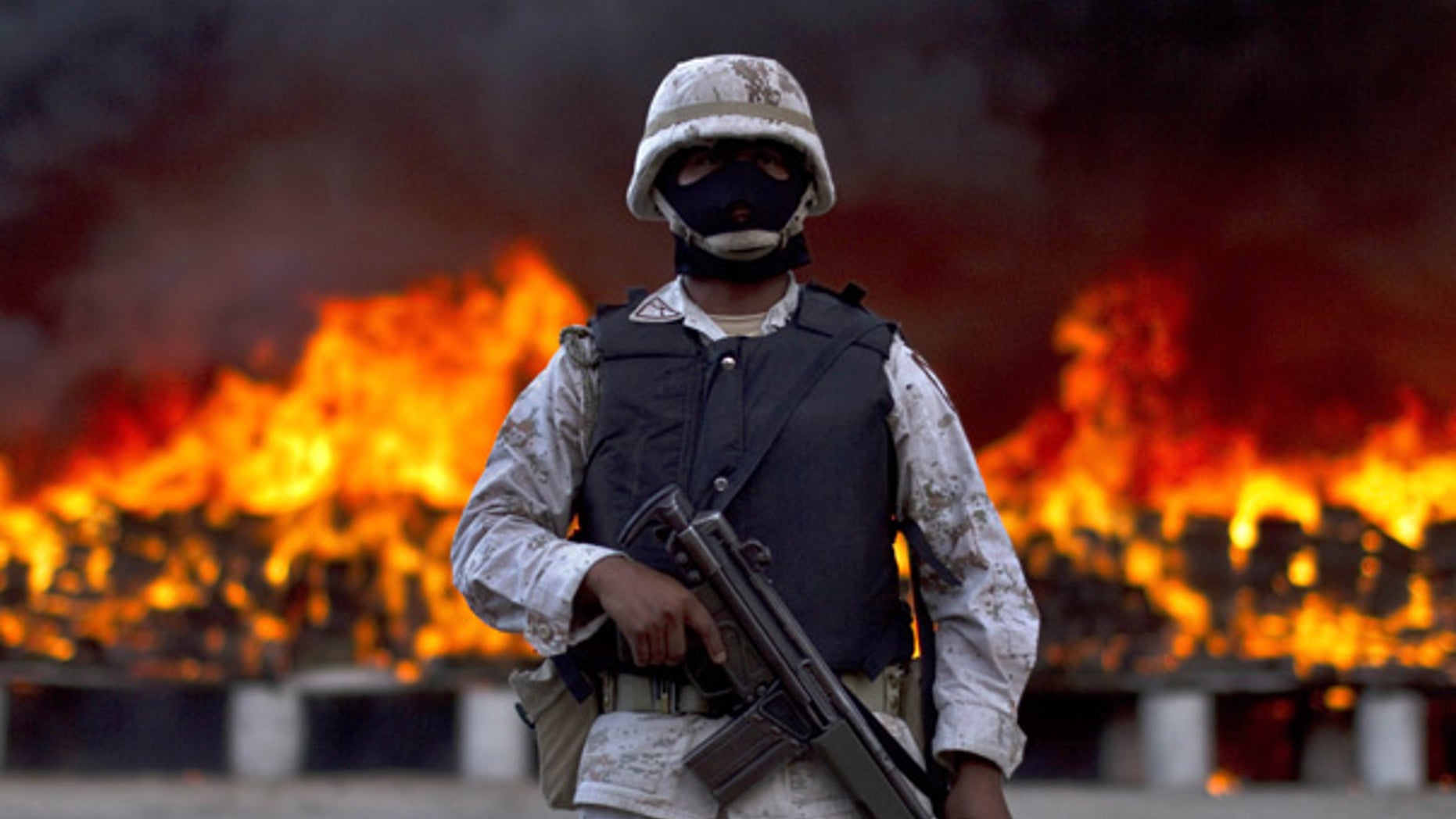 Oct. 20: A soldier guards packages of marijuana being incinerated after army and police seized 134 tons of U.S.-bound pot in Tijuana.