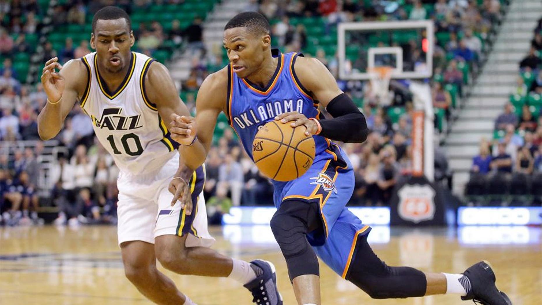 Oklahoma City Thunder guard Russell Westbrook, right, drives around Utah Jazz guard Alec Burks during the second half of an NBA preseason basketball game Tuesday, Oct. 20, 2015, in Salt Lake City. The Thunder won 113-102. (AP Photo/Rick Bowmer)