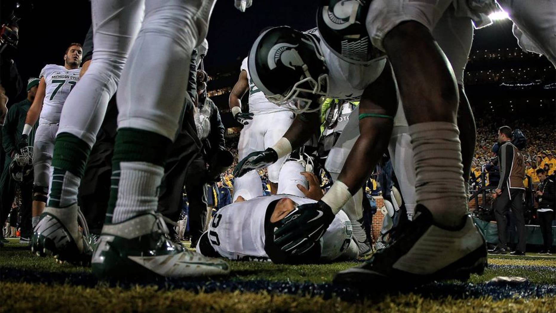 Oct 17, 2015; Ann Arbor, MI, USA; Injured Michigan State Spartans defensive back Jalen Watts-Jackson (20) is talked to by teamates before being carted off the field during the 2nd half of a game at Michigan Stadium. Mandatory Credit: Mike Carter-USA TODAY Sports