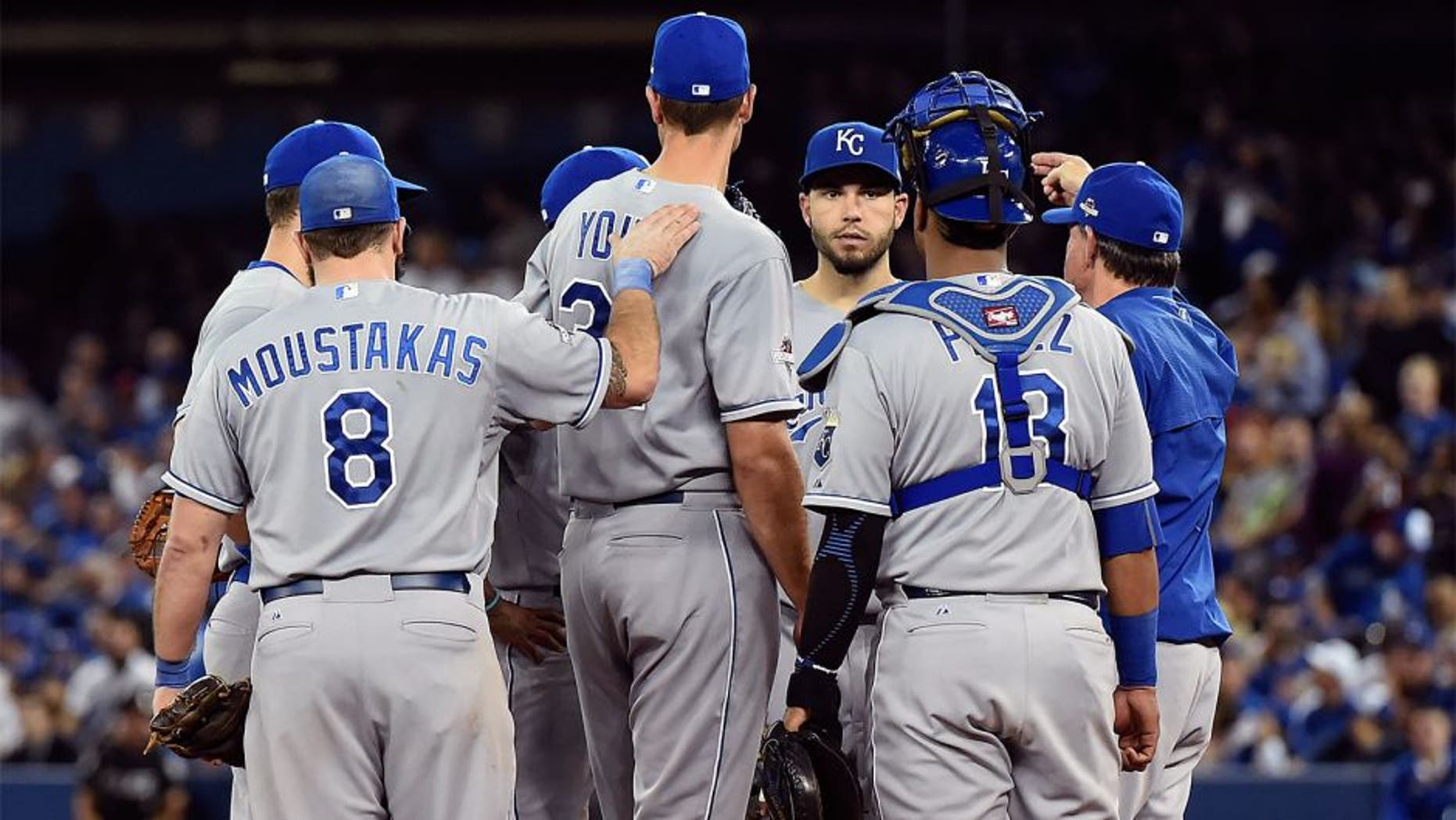 Oct 20, 2015; Toronto, Ontario, CAN; Kansas City Royals starting pitcher Chris Young (32) is patted on the back by third baseman Mike Moustakas (8) as manager Ned Yost (3) relieves him during the fifth inning against the Toronto Blue Jays in game four of the ALCS at Rogers Centre. Mandatory Credit: Dan Hamilton-USA TODAY Sports