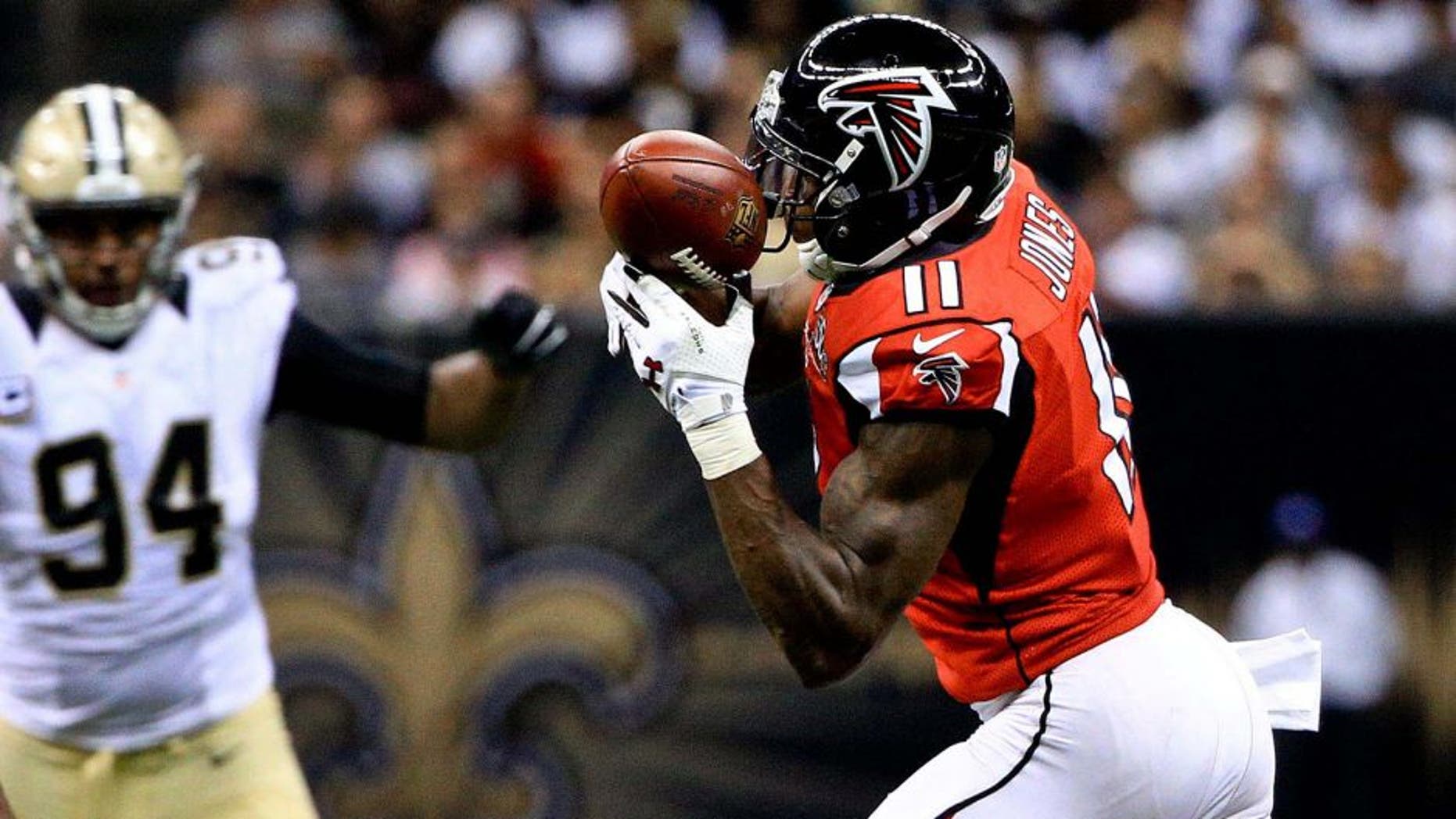 Oct 15, 2015; New Orleans, LA, USA; Atlanta Falcons wide receiver Julio Jones (11) catches a pass as New Orleans Saints linebacker Dannell Ellerbe (59) and defensive end Cameron Jordan (94) defend during the second half of a game at the Mercedes-Benz Superdome. Mandatory Credit: Derick E. Hingle-USA TODAY Sports