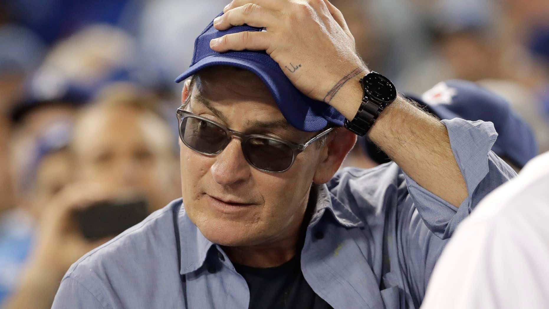 Actor Charlie Sheen reacts during the fifth inning of Game 4 of the National League baseball championship series between the Chicago Cubs and the Los Angeles Dodgers Wednesday, Oct. 19, 2016, in Los Angeles.