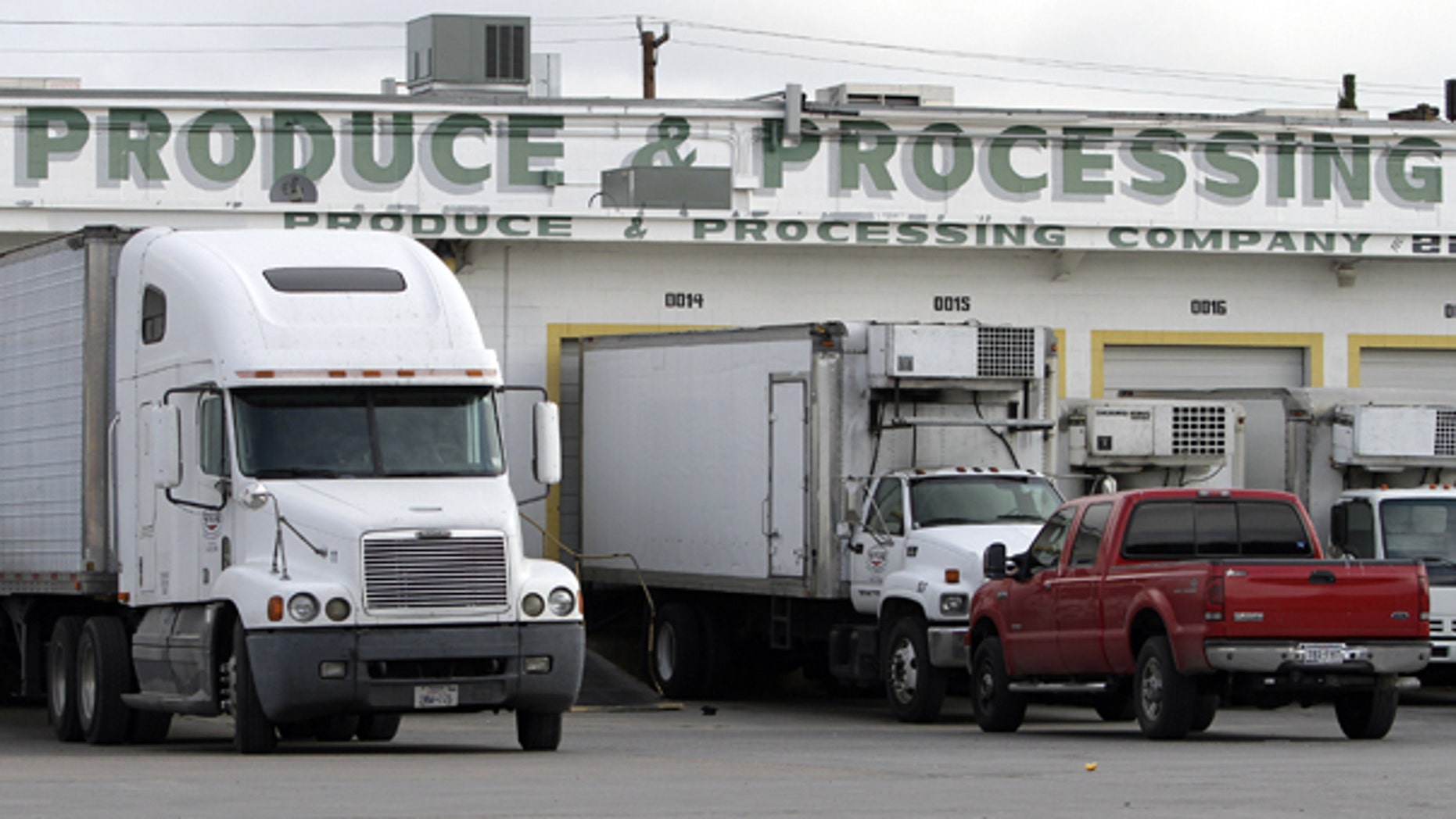 Oct. 21: Trucks are seen in front of the SanGar food processing plant in San Antonio. Texas health officials investigating five deaths have closed the facility and ordered a recall of all products shipped from there since January.