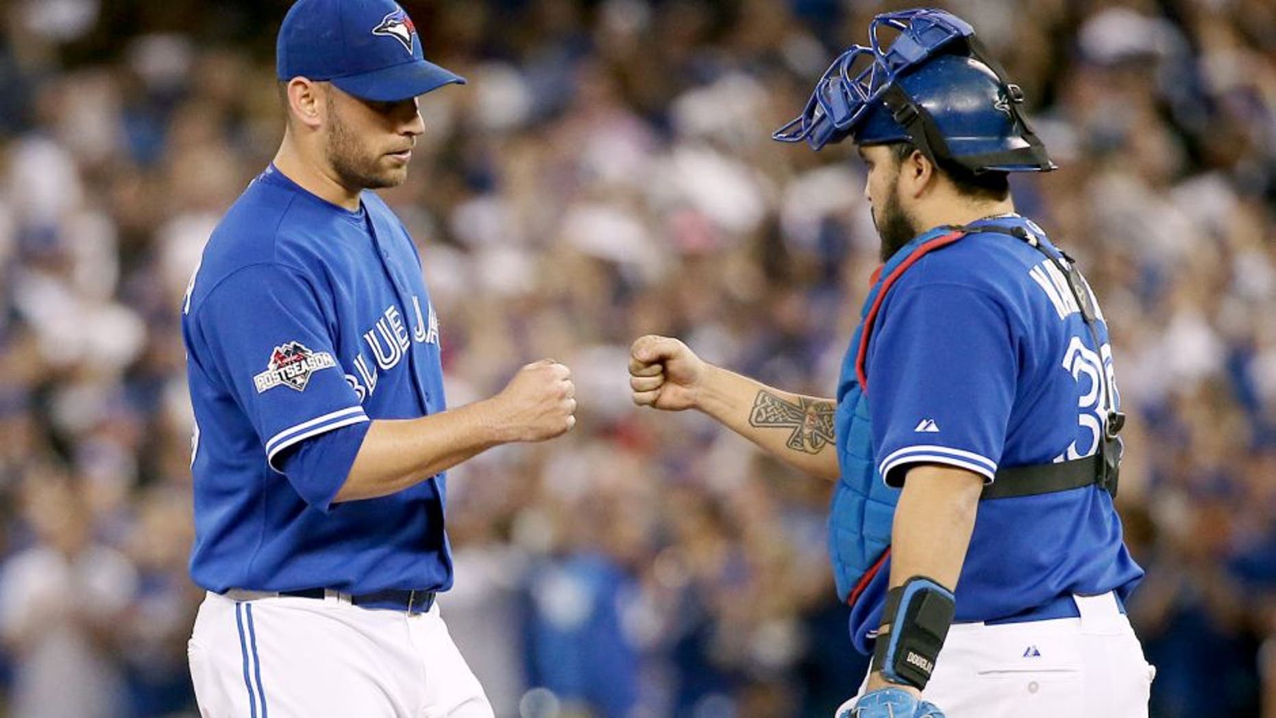 TORONTO, ON - OCTOBER 21: Toronto Blue Jays starting pitcher Marco Estrada (25) (left) gets a fist bump from catcher Dioner Navarro just before he's pulled from the game in the 7th inning. Toronto Blue Jays V Kansas City Royals in Game 5 of the American League Championship Series in MLB action at Rogers Centre. Jays win 7-1 and head back to KC for Game 6 trailing in the series 3-2. Toronto Star/Rick Madonik (Rick Madonik/Toronto Star via Getty Images)
