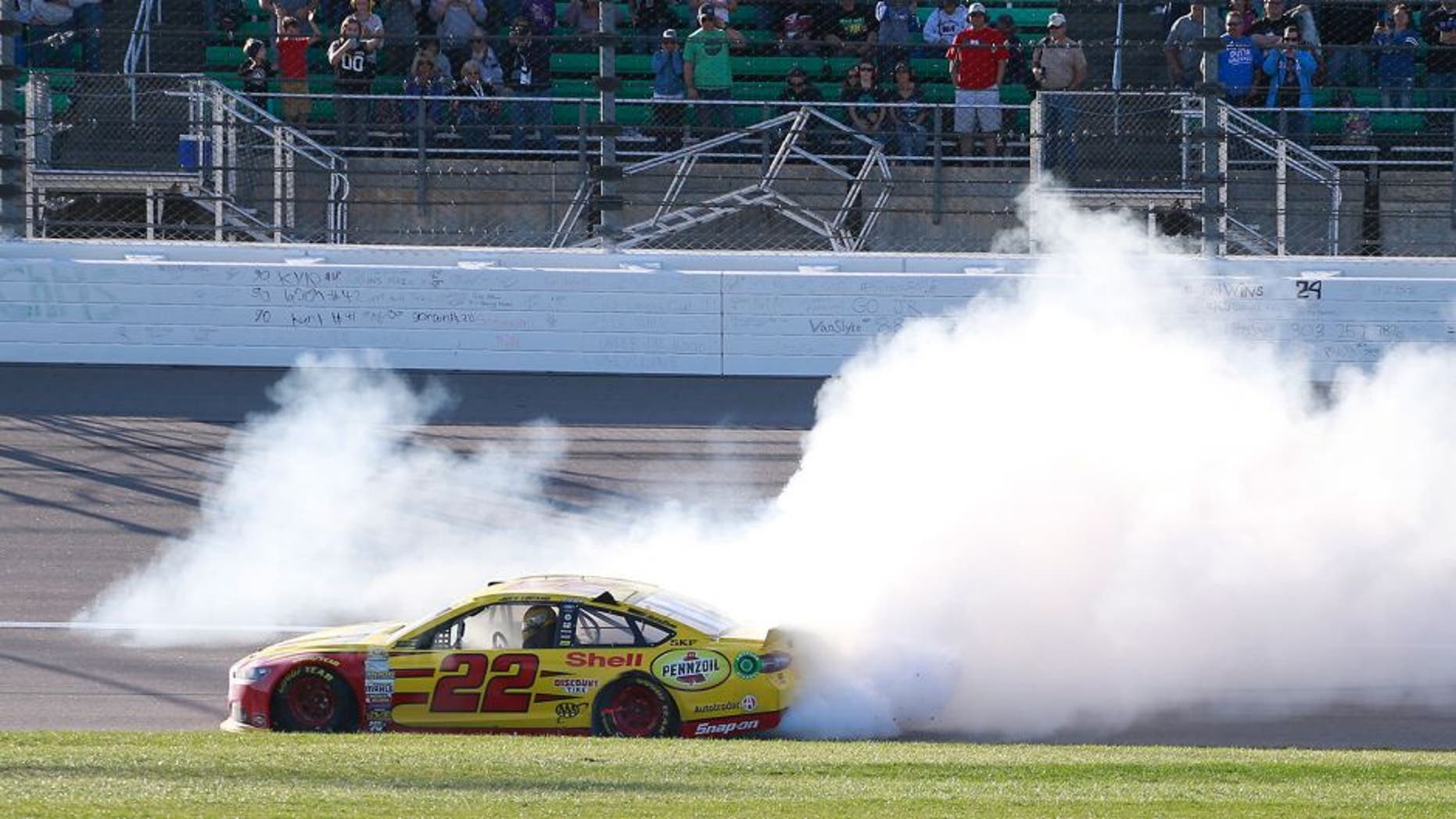 KANSAS CITY, KS - OCTOBER 18: Joey Logano, driver of the #22 Shell Pennzoil Ford, celebrates with a burnout after winning the NASCAR Sprint Cup Series Hollywood Casino 400 at Kansas Speedway on October 18, 2015 in Kansas City, Kansas. (Photo by Matt Sullivan/Getty Images)