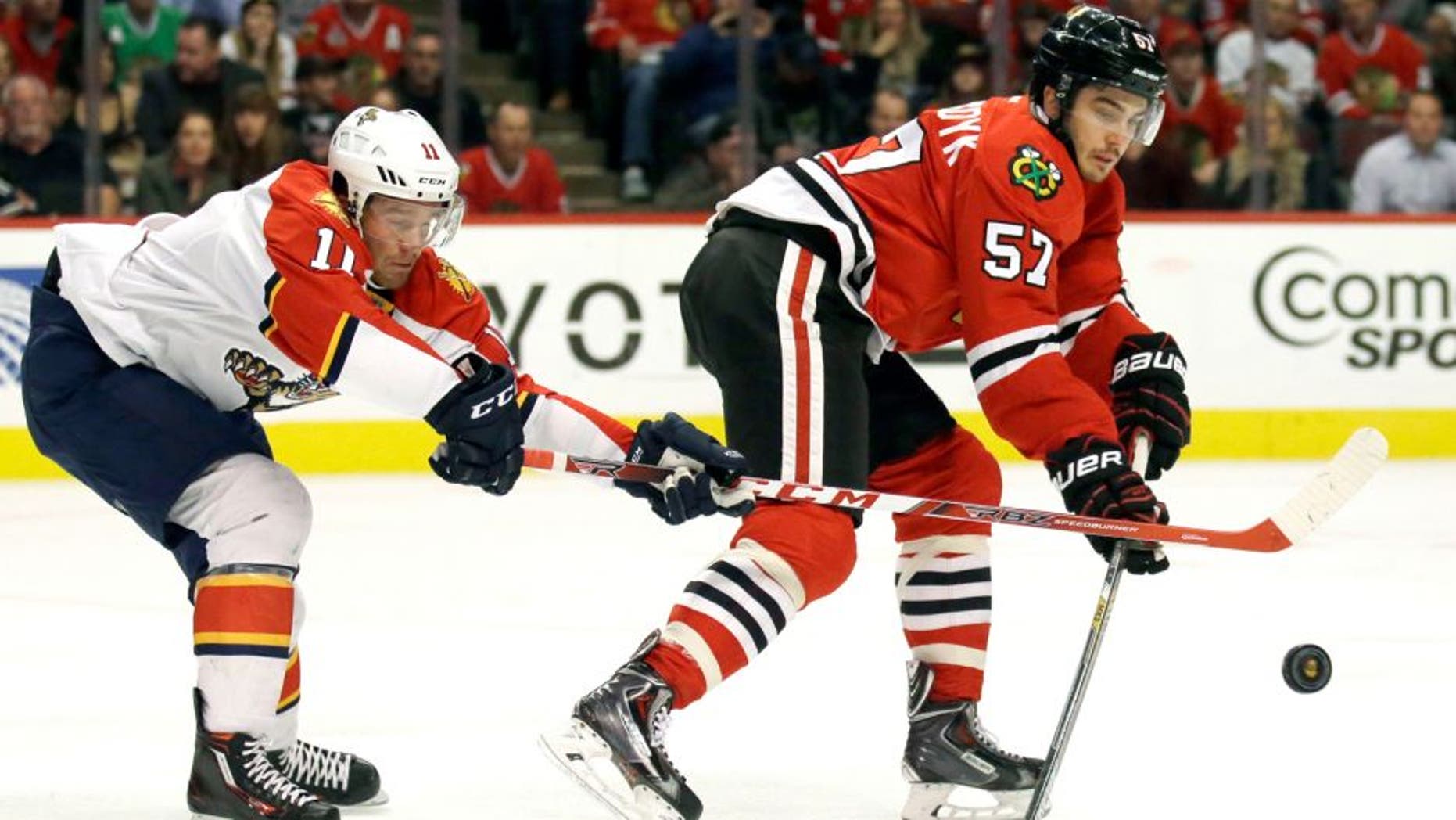 Florida Panthers left wing Jonathan Huberdeau, left, and Chicago Blackhawks defenseman Trevor van Riemsdyk battle for the puck during the first period of an NHL hockey game Thursday, Oct. 22, 2015, in Chicago. (AP Photo/Nam Y. Huh)