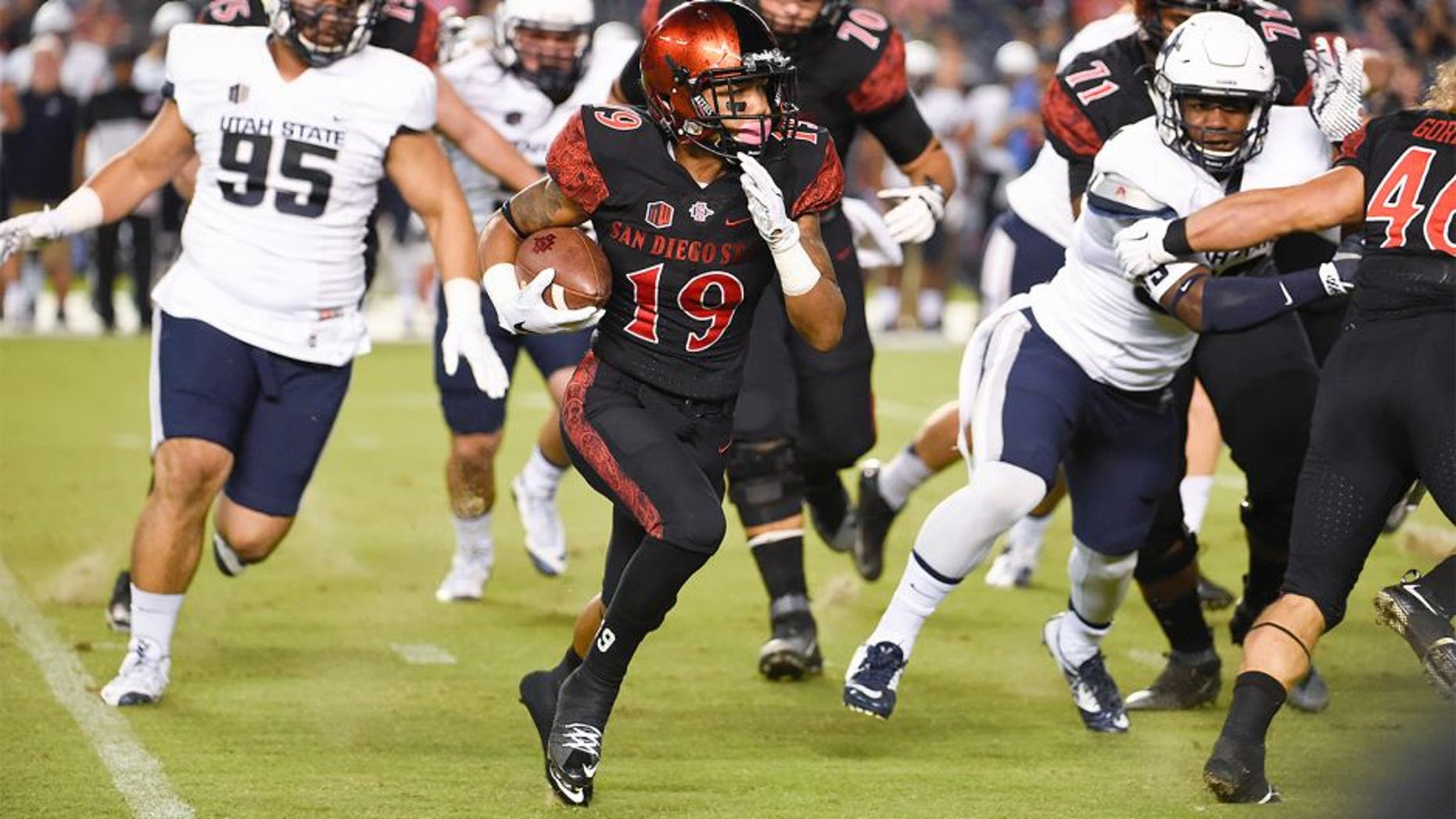 San Diego State running back Donnel Pumphrey (19) carries past the Utah State defense during the first half of an NCAA college football game Friday, Oct. 23, 2015 in San Diego. (AP Photo/Denis Poroy)