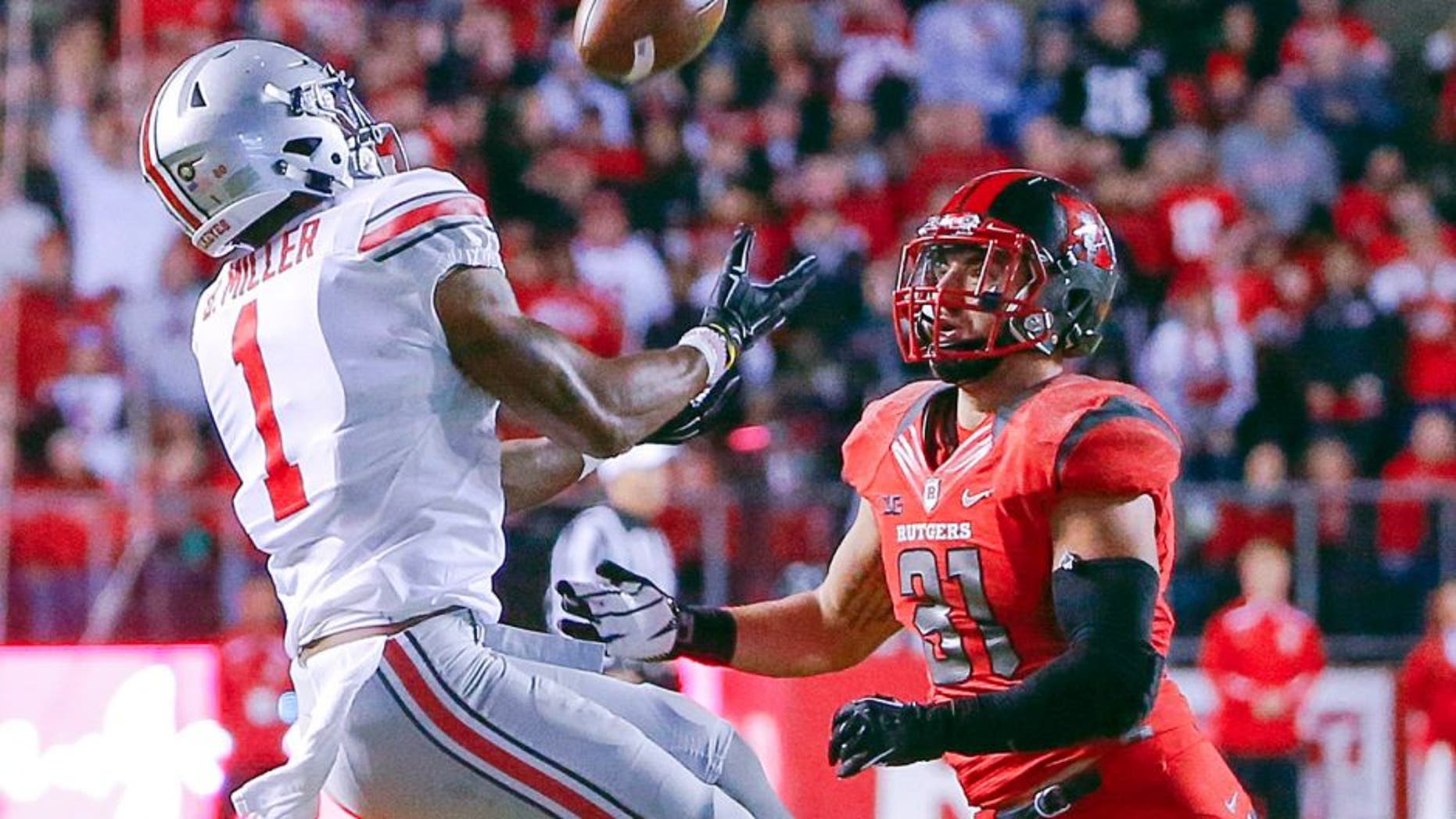 Oct 24, 2015; Piscataway, NJ, USA; Ohio State Buckeyes wide receiver Braxton Miller (1) pulls in long pass during the second quarter against Rutgers Scarlet Knights running back Charles Snorweah (21) at High Points Solutions Stadium. Mandatory Credit: Jim O'Connor-USA TODAY Sports